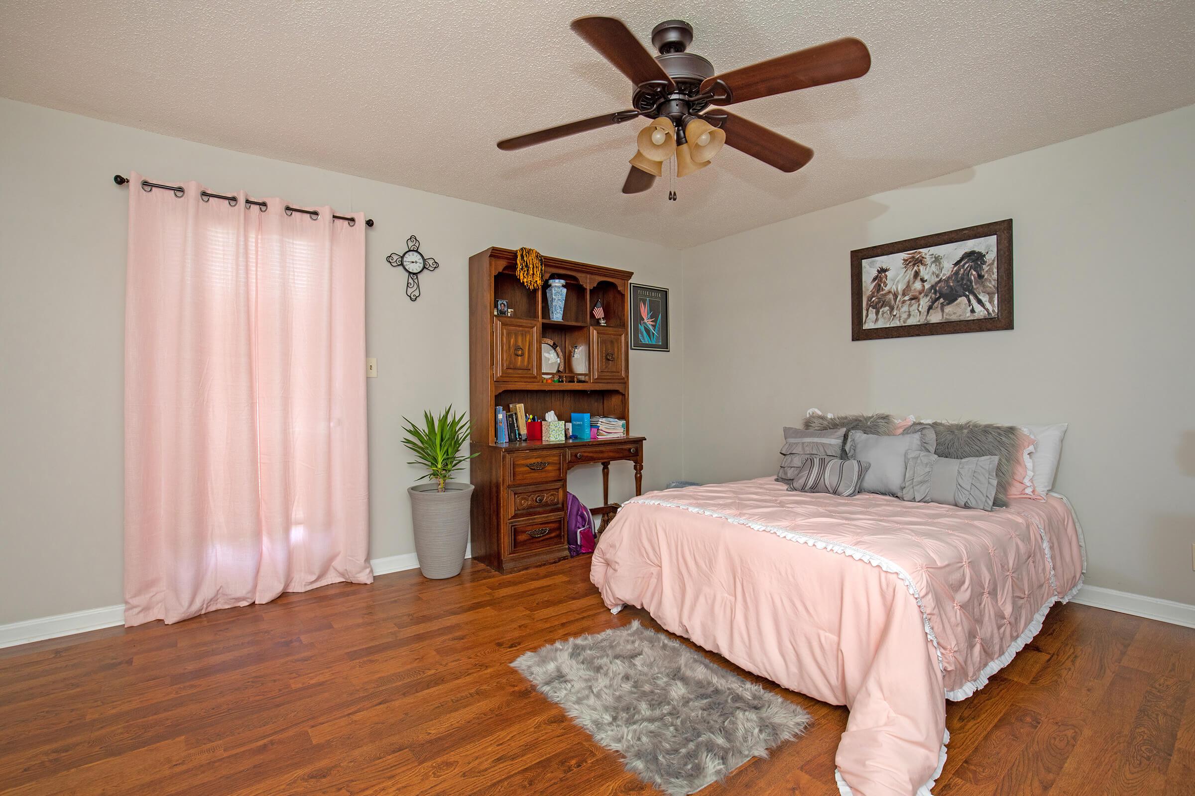 a bedroom with a bed and desk in a room
