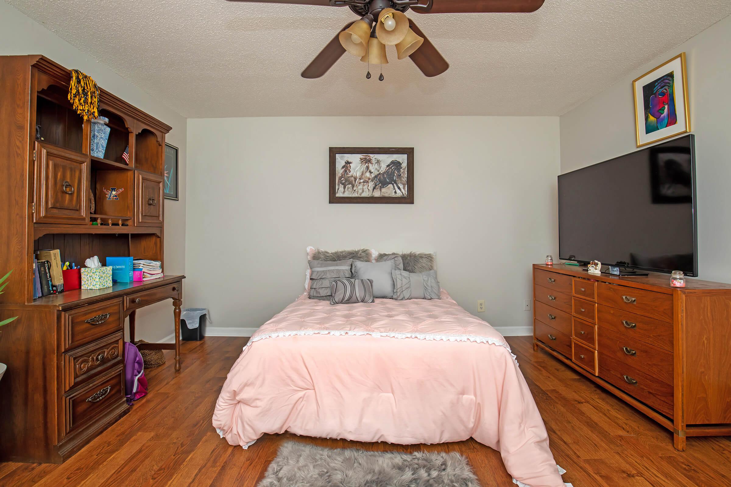 a bedroom with a bed and desk in a room