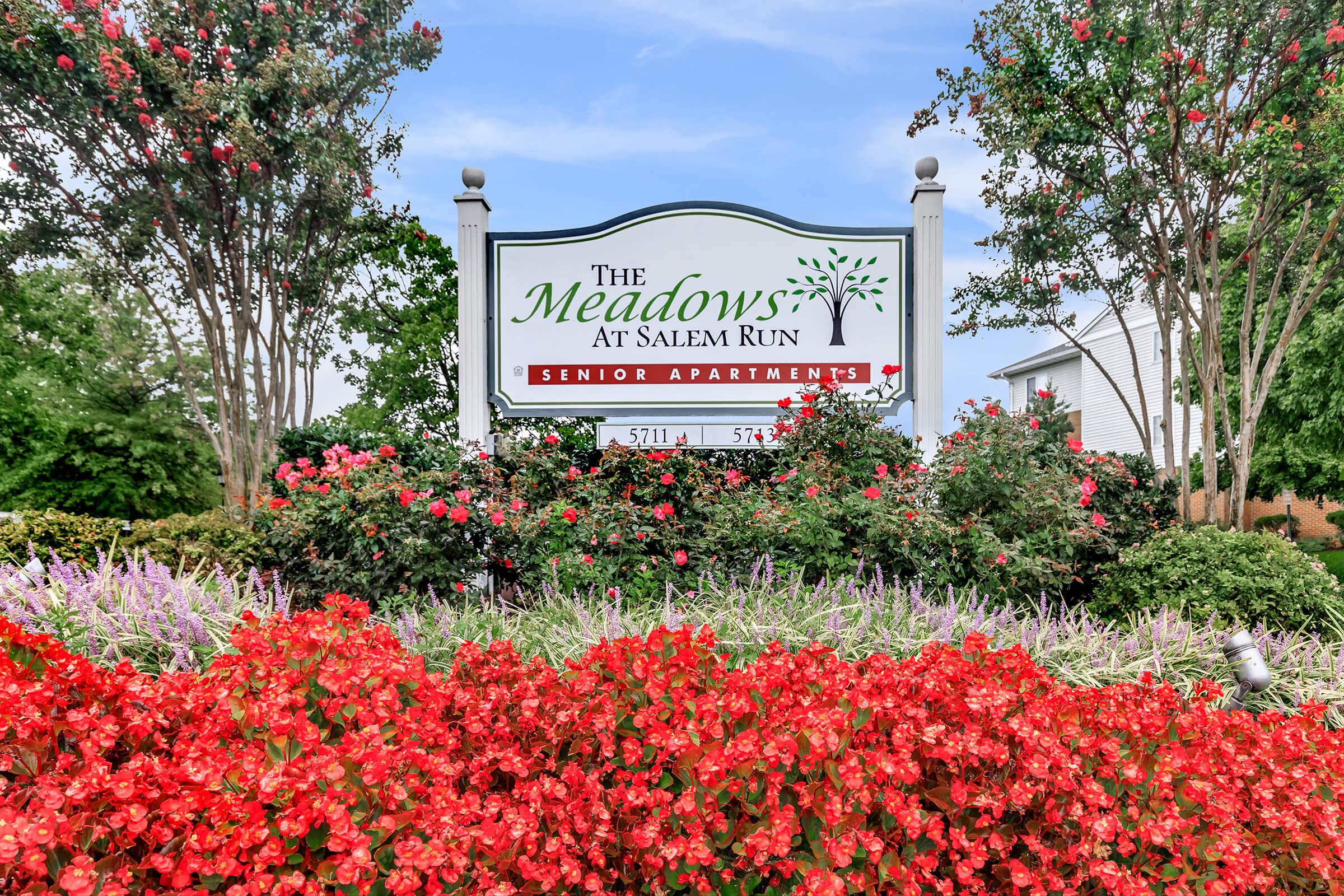 a sign in front of a flower garden