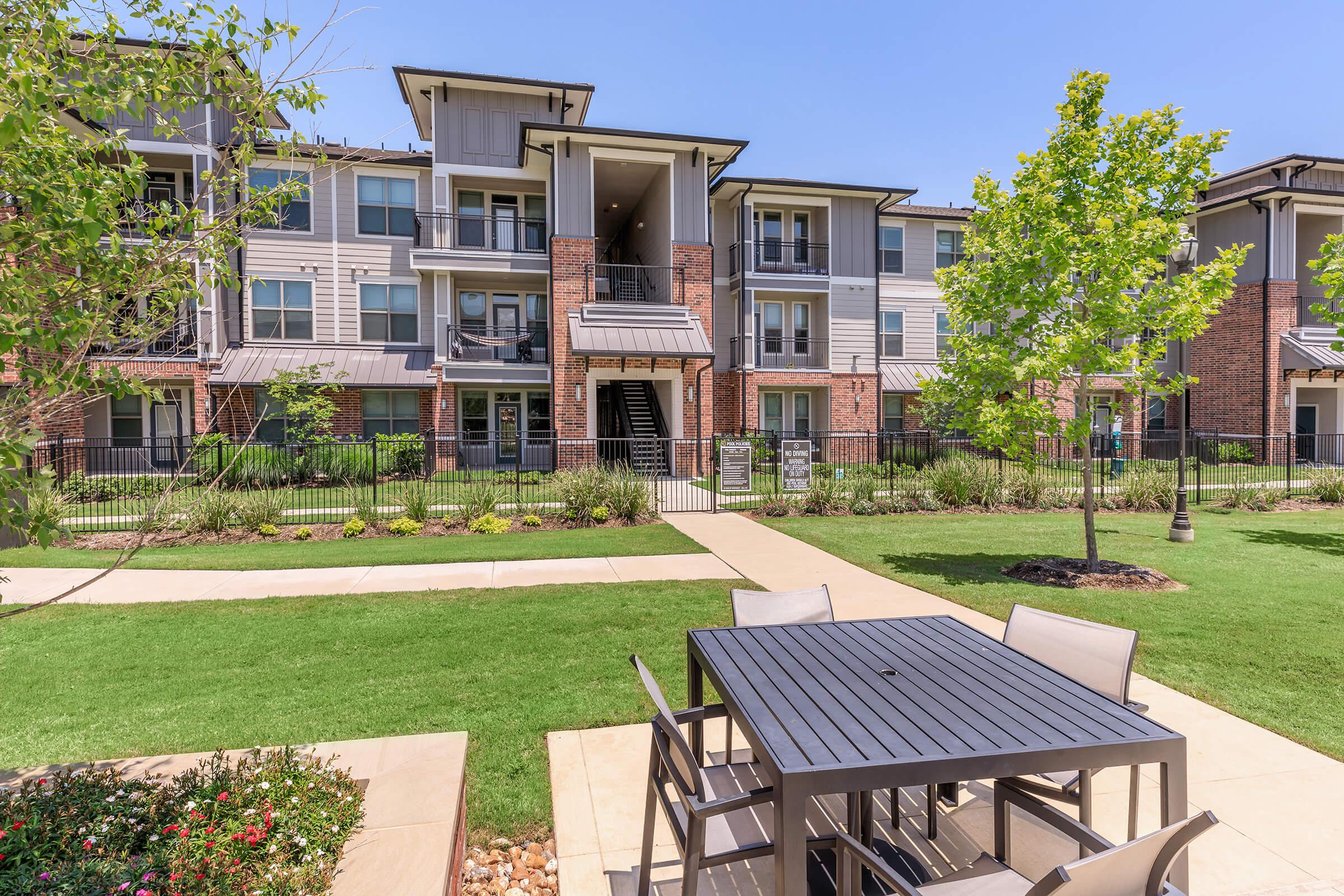 a large lawn in front of a brick building