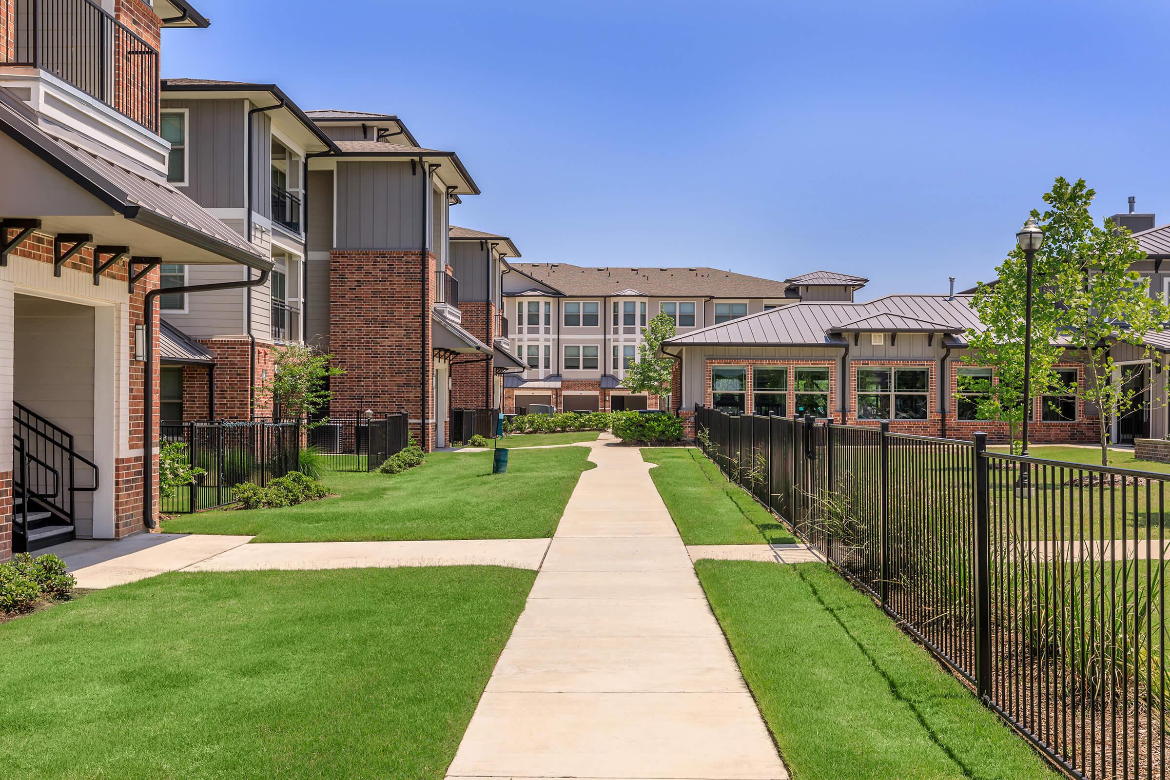 a house with a lawn in front of a brick building