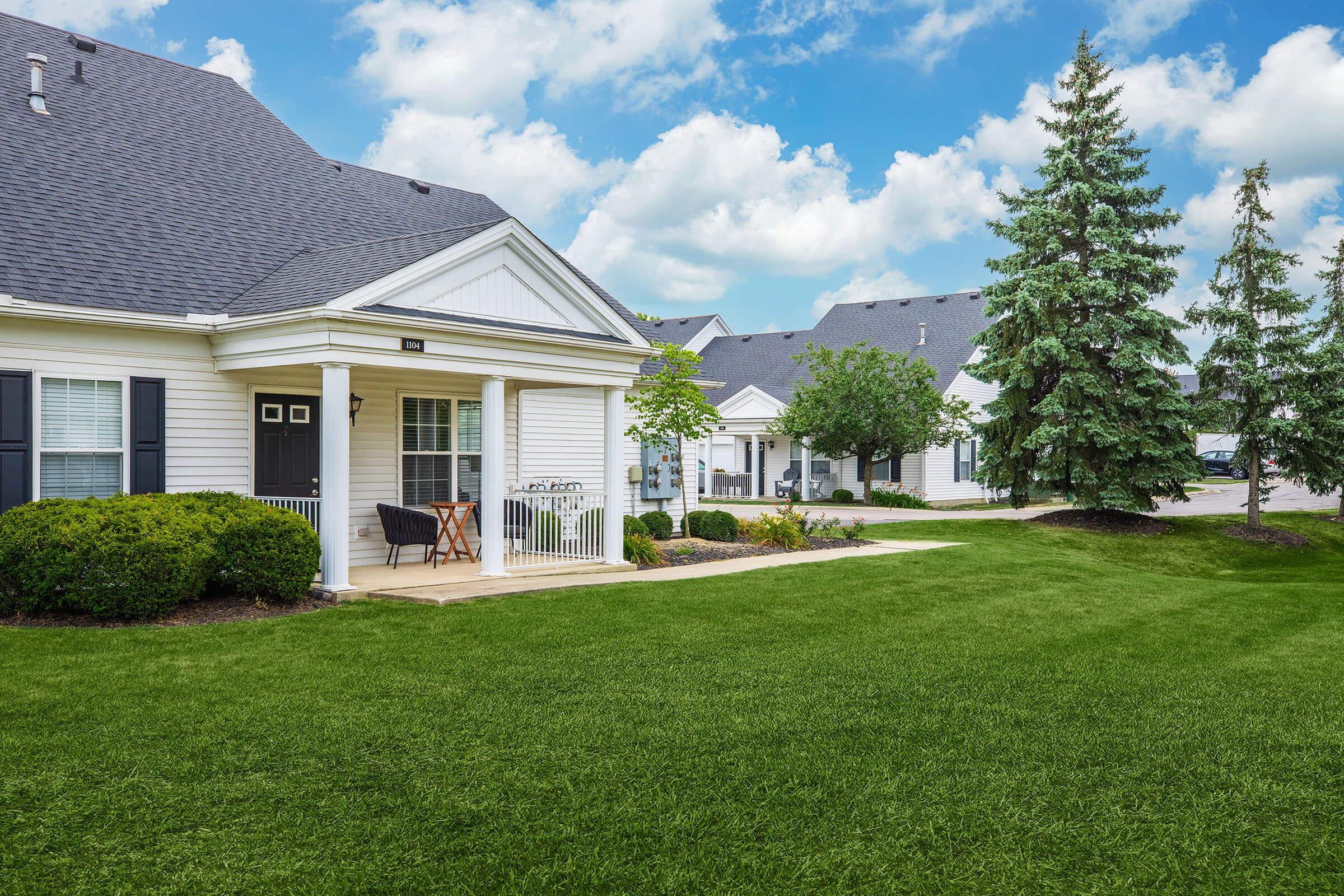 a large green field in front of a house