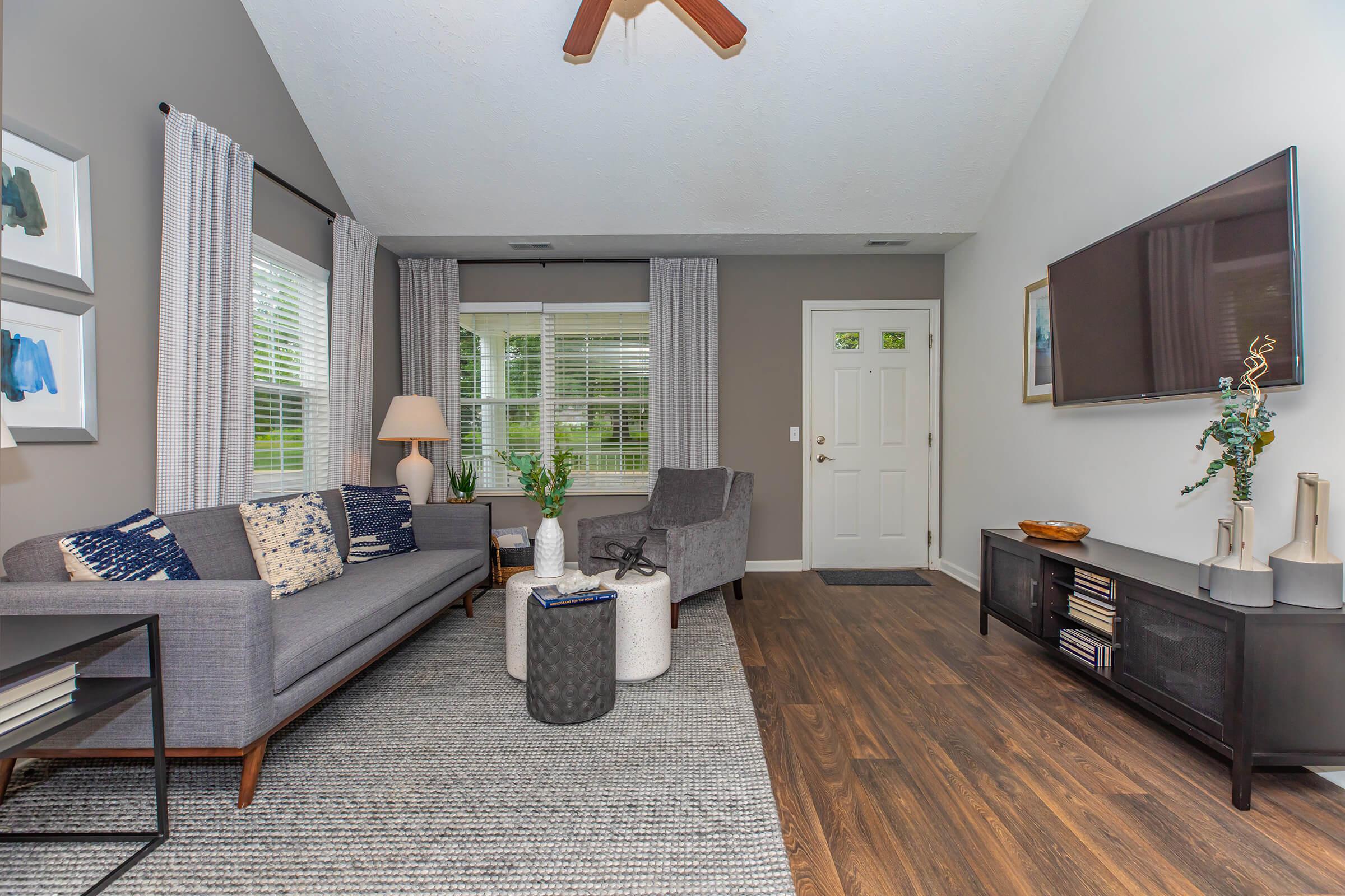 a living room filled with furniture and a large window