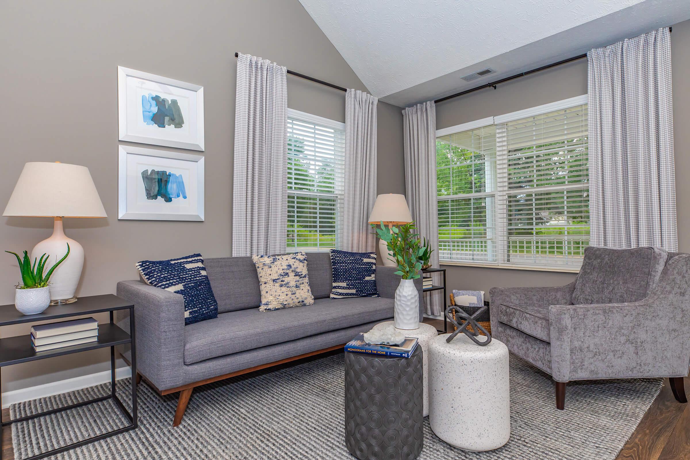 a living room filled with furniture and a large window