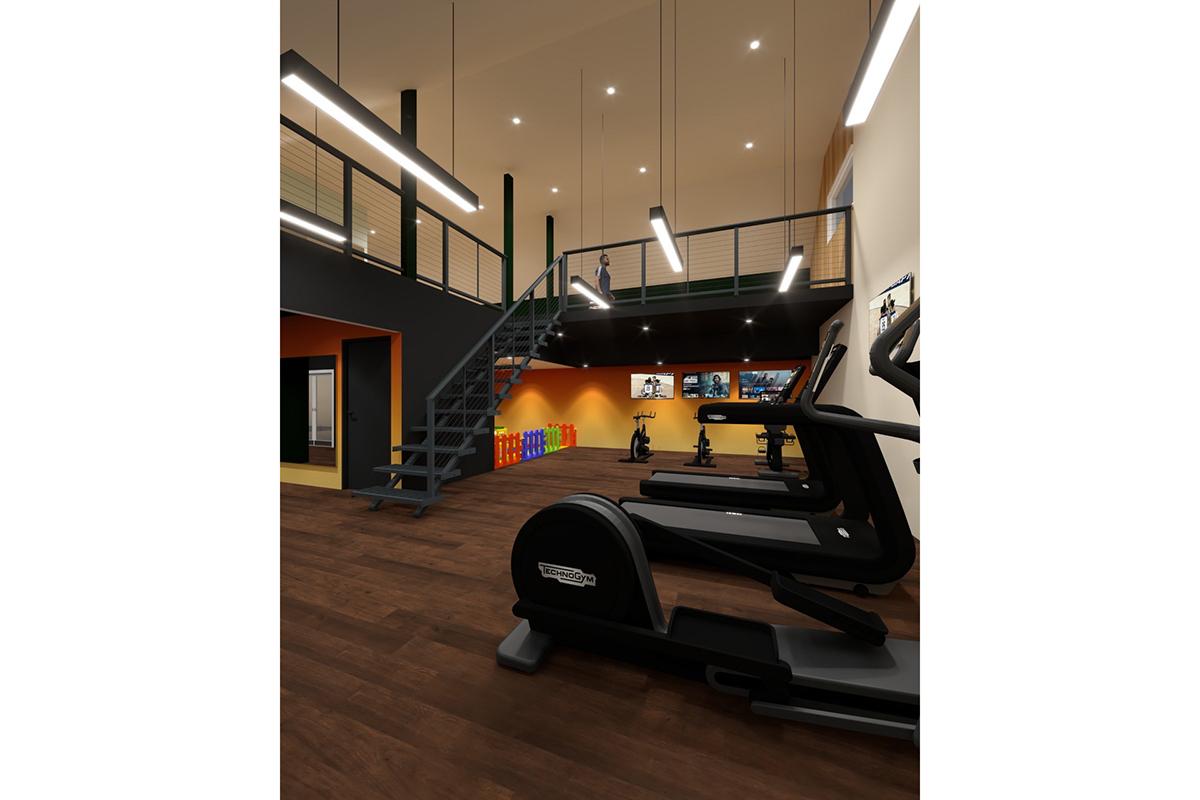 Interior view of a modern gym featuring exercise equipment like a stationary bike and ellipticals. A staircase leads to an upper level, and the walls are painted in warm colors. Multiple screens are mounted on the wall, and colorful storage bins are visible in the background. Brightly lit with high ceilings.