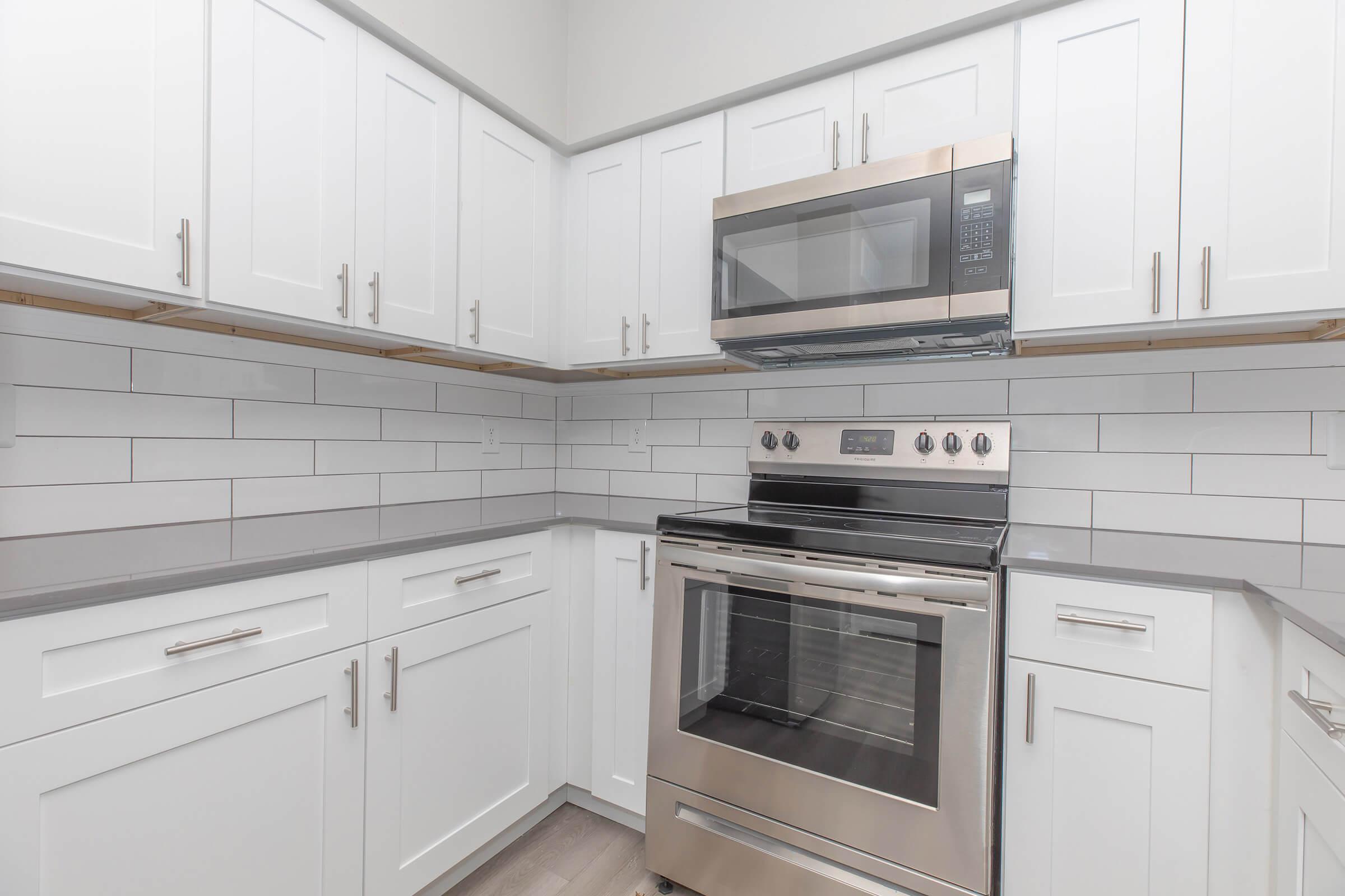 a stove top oven sitting inside of a kitchen