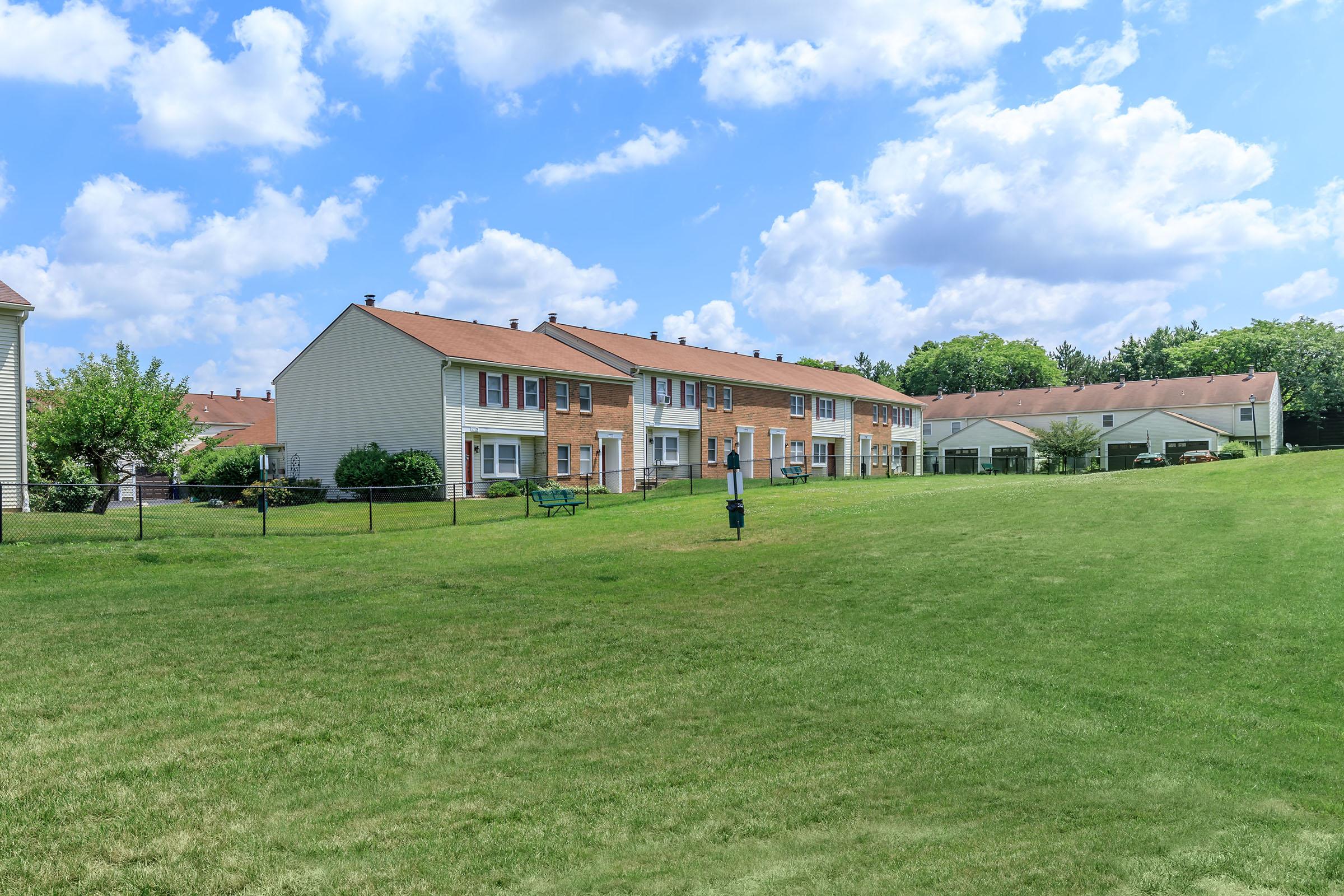 a large green field in front of a house