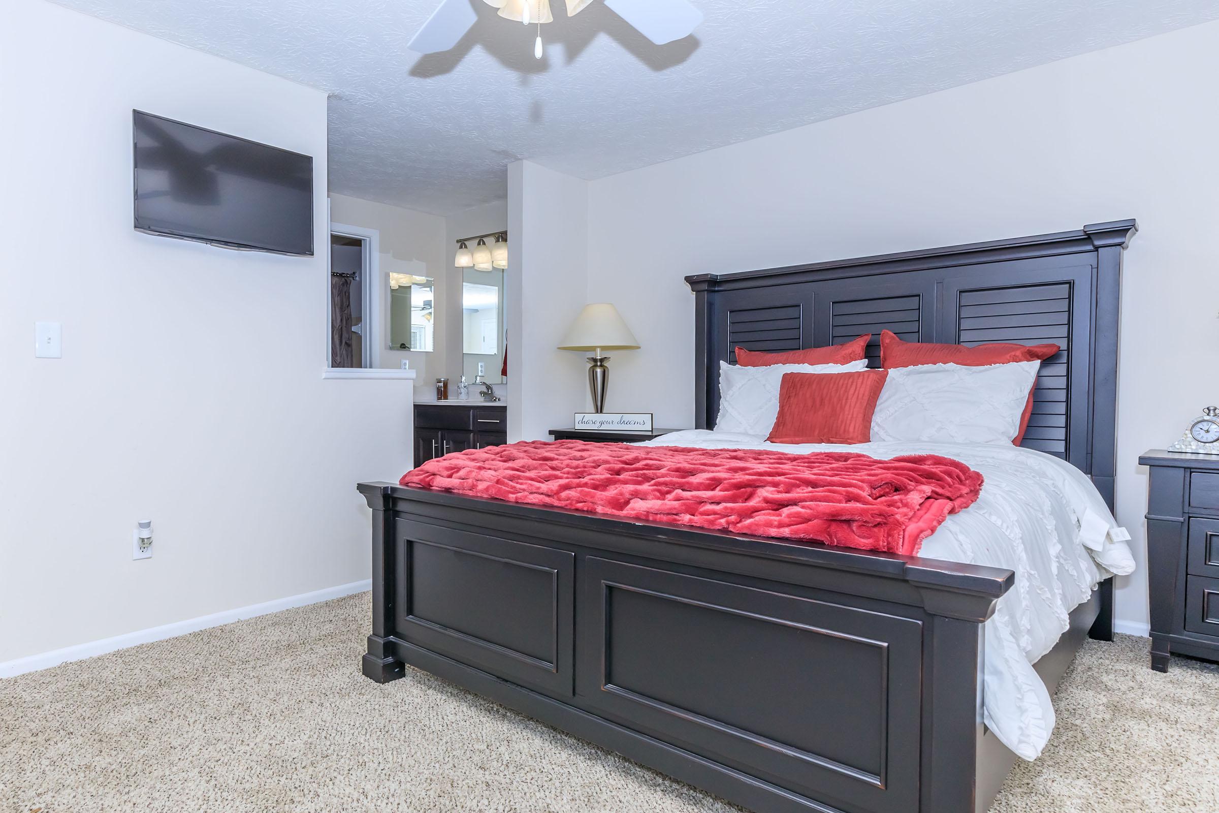 a bedroom with a bed and desk in a room