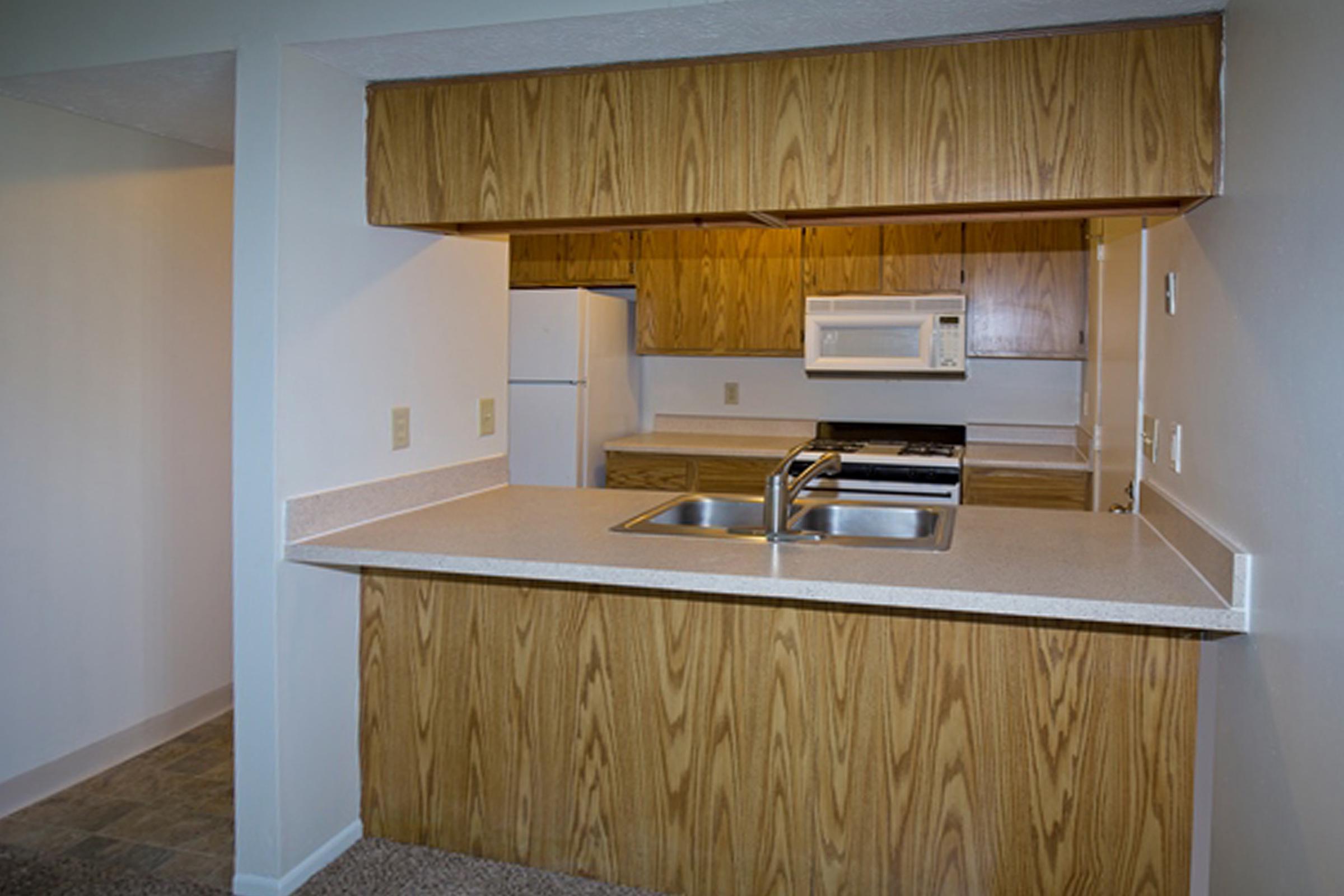 a kitchen with wooden cabinets and a microwave