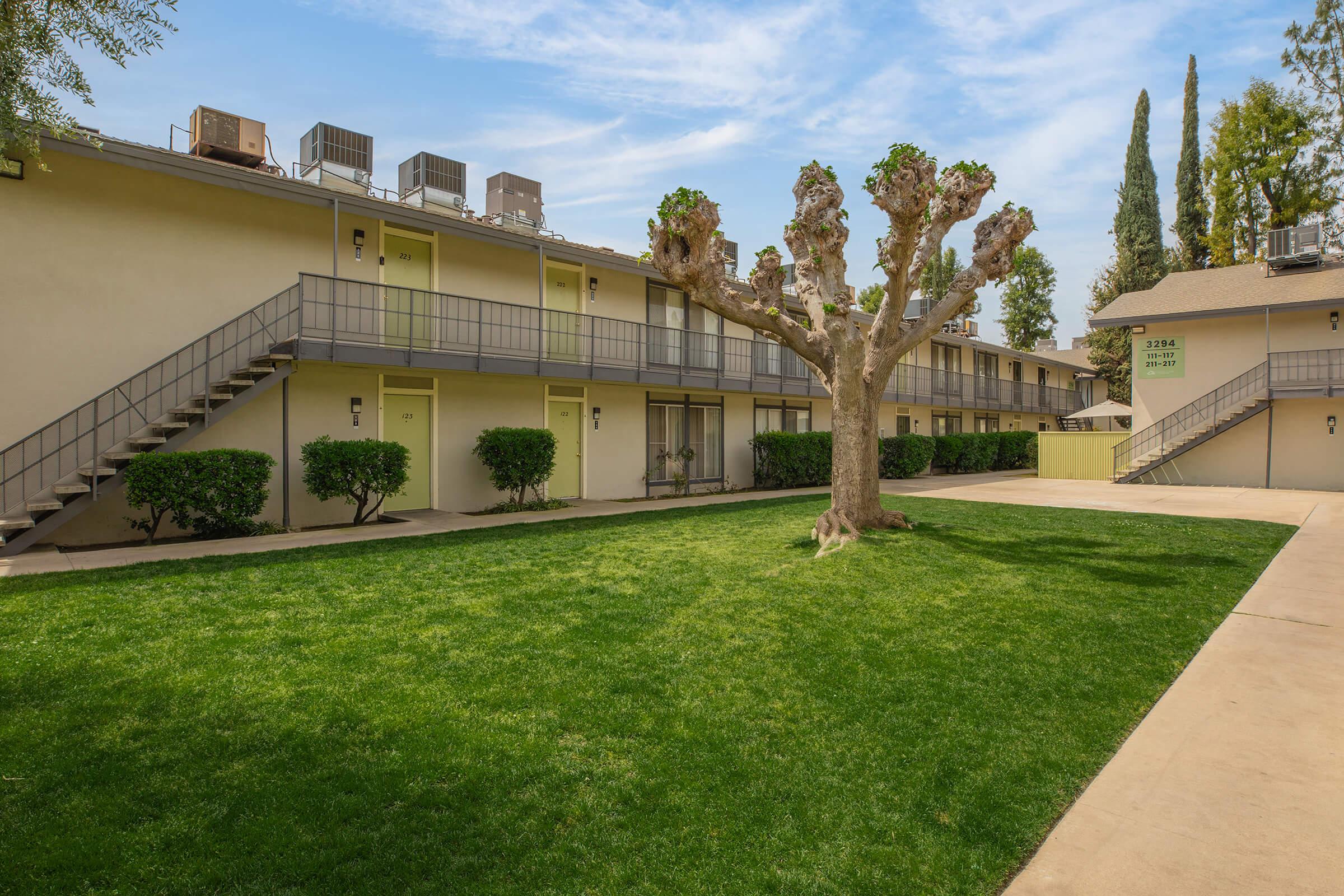 a large brick building with green grass