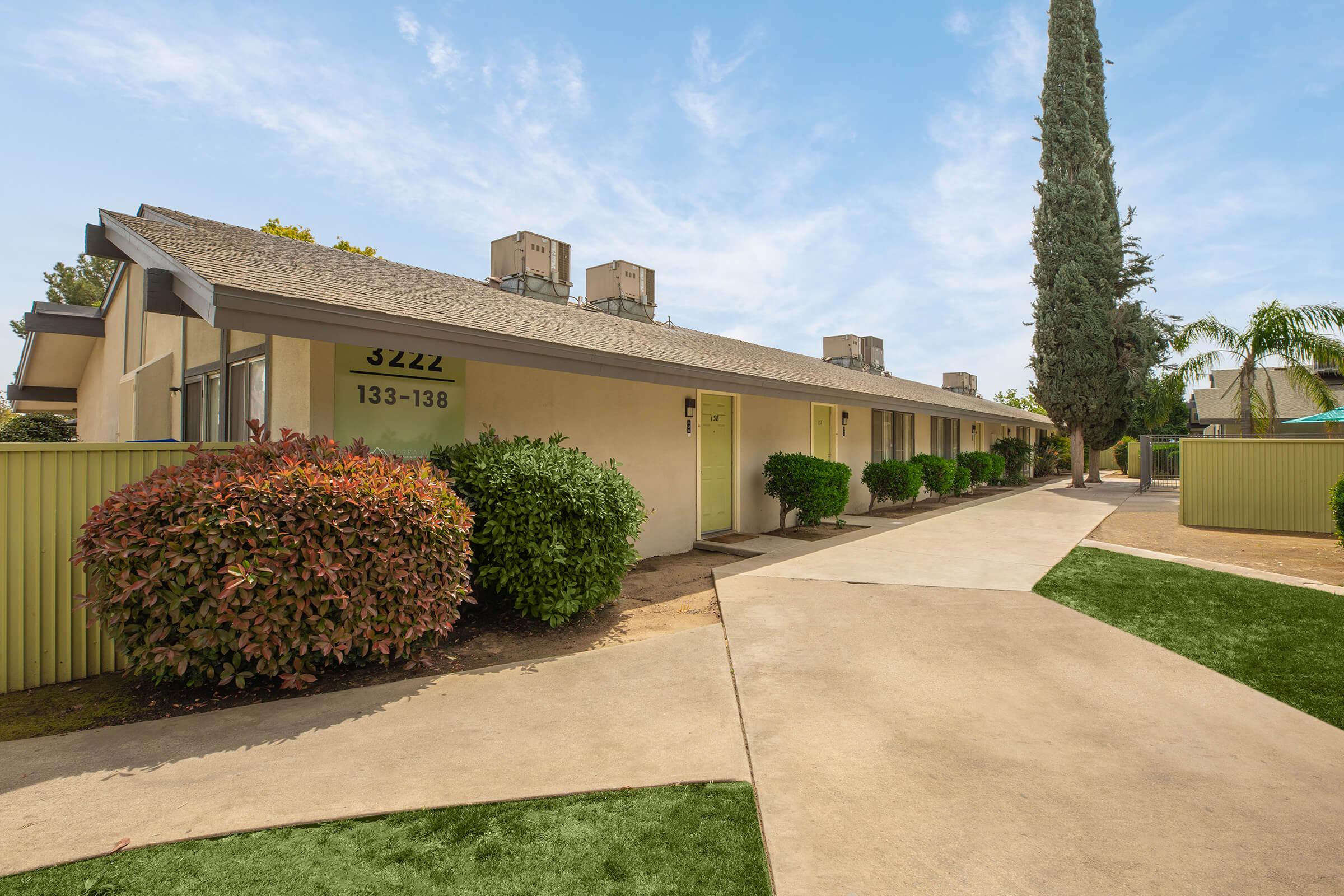 a large brick building with grass and trees