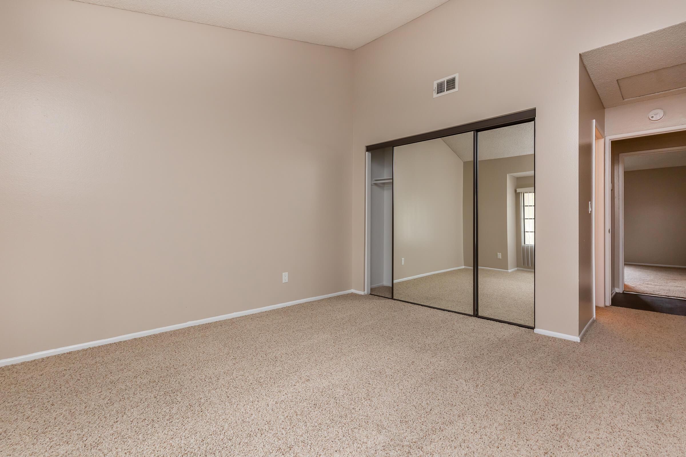 Bedroom with sliding mirror glass closet doors