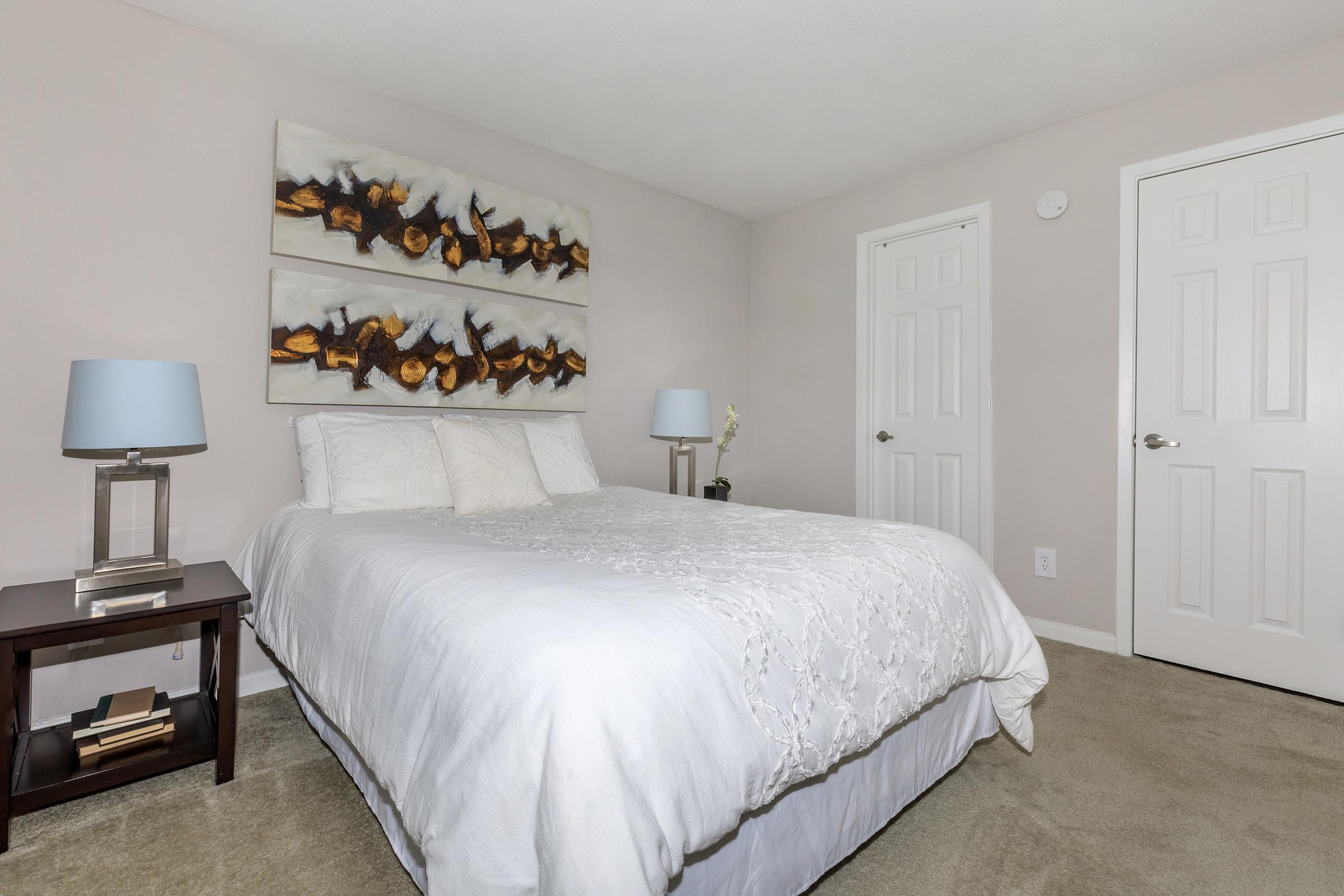 a bedroom with a bed and desk in a hotel room