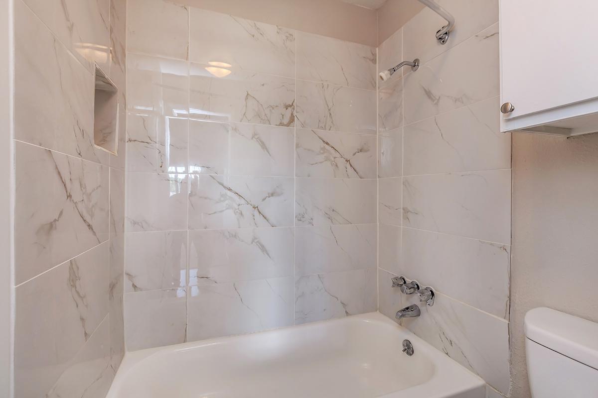 a white tub sitting next to a shower