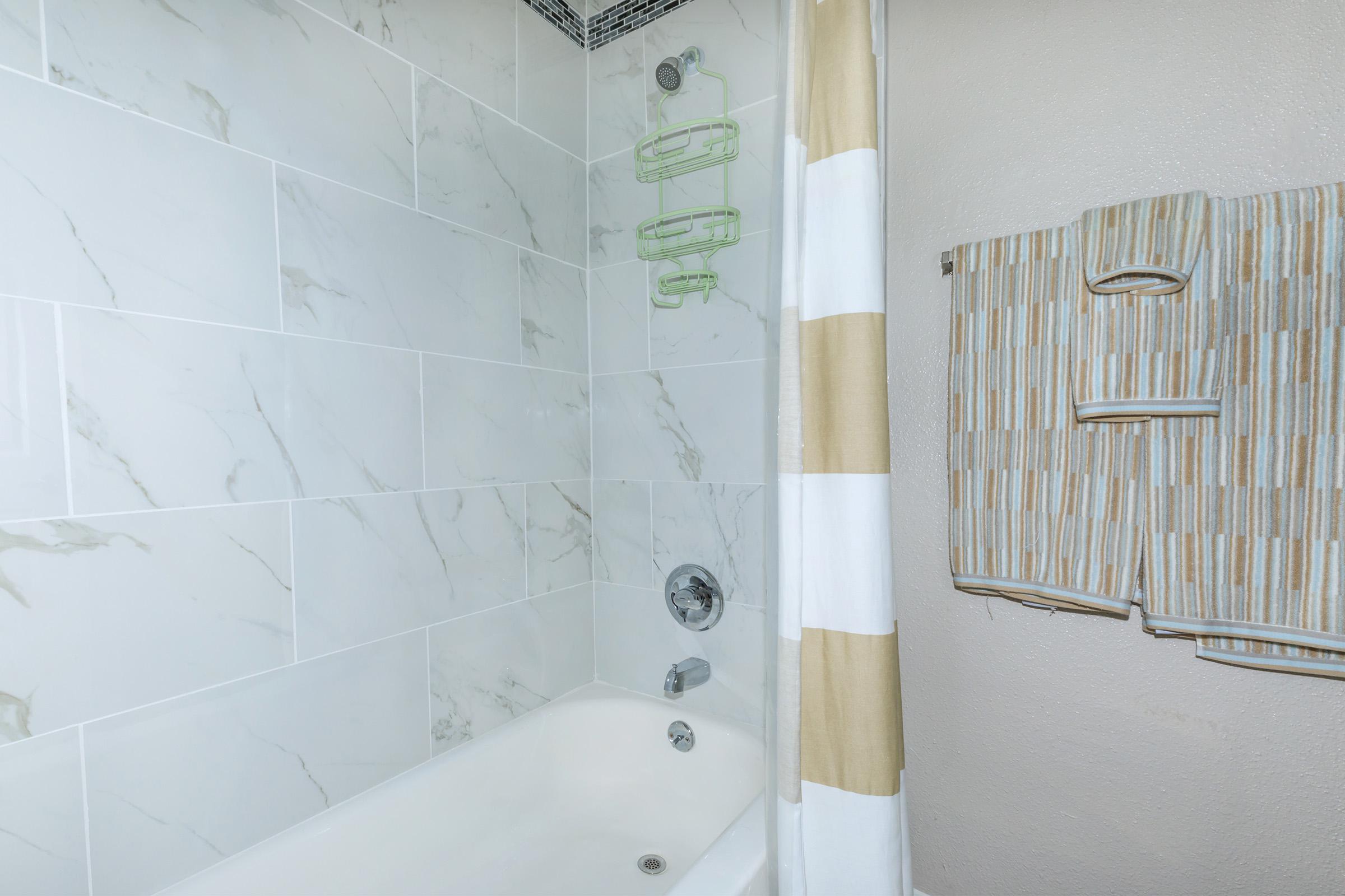 a white tub sitting next to a shower