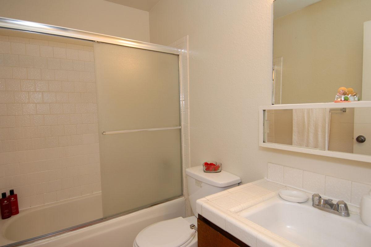 a white sink sitting under a mirror