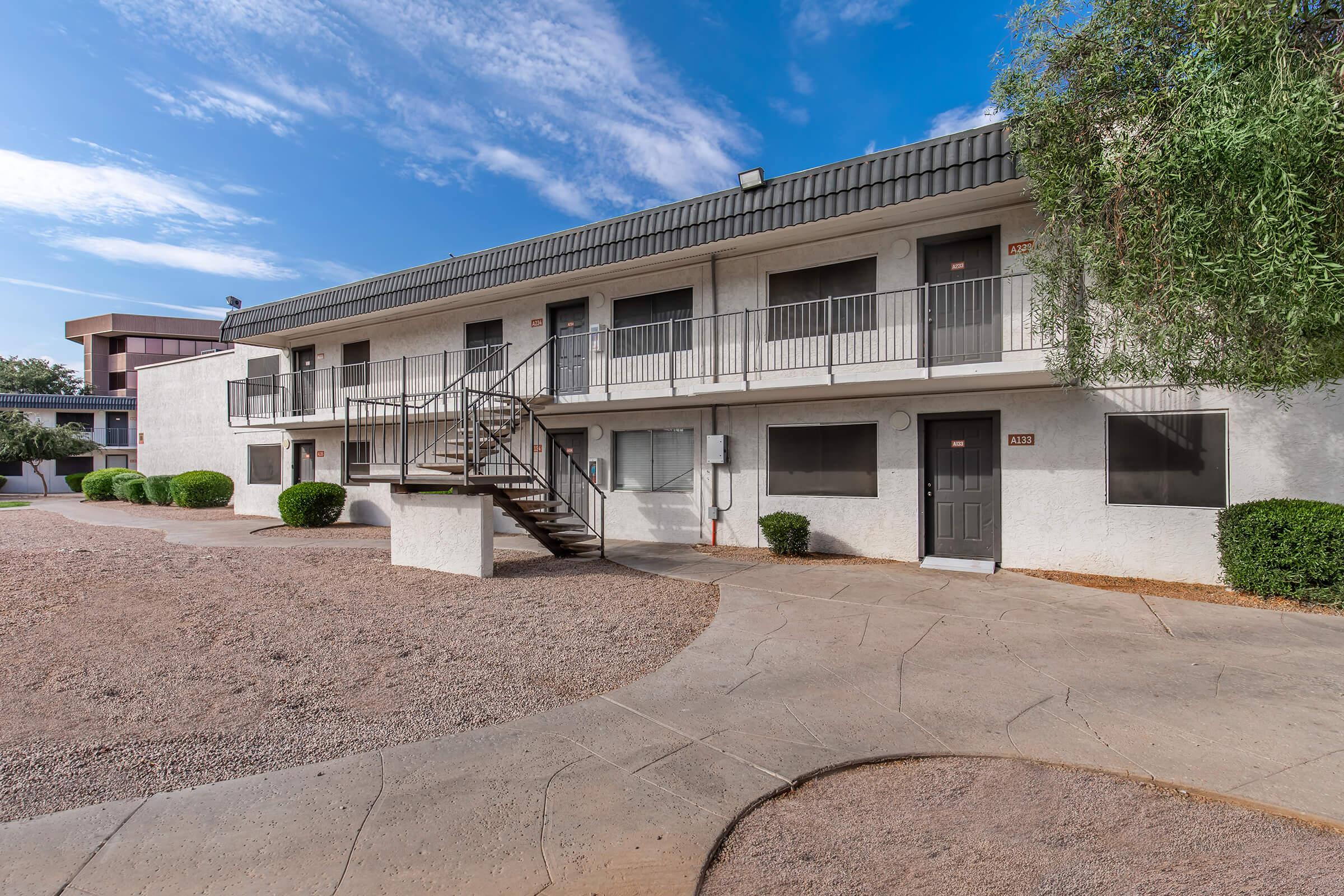 a dirt road in front of a building