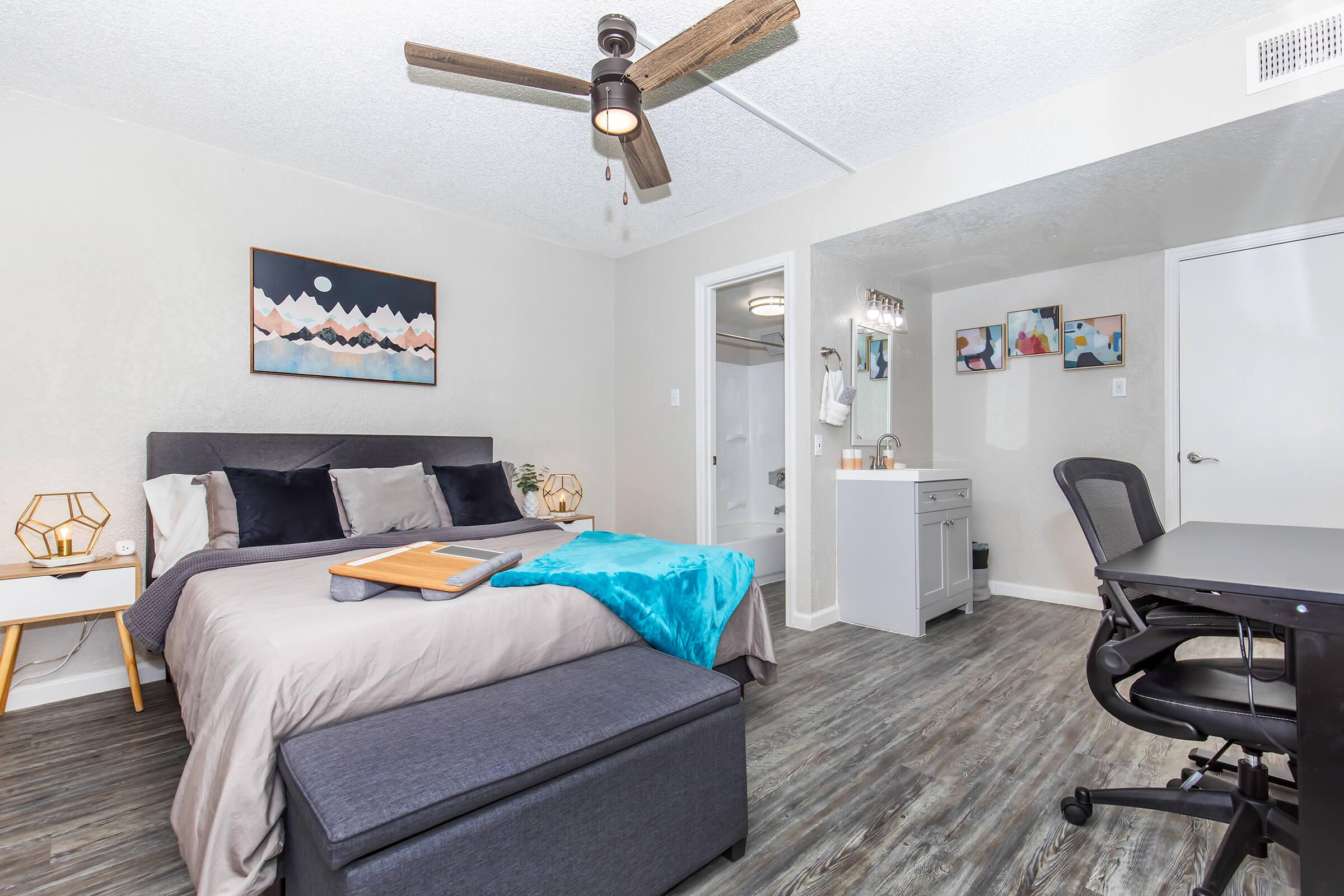 a bedroom with a bed and desk in a room