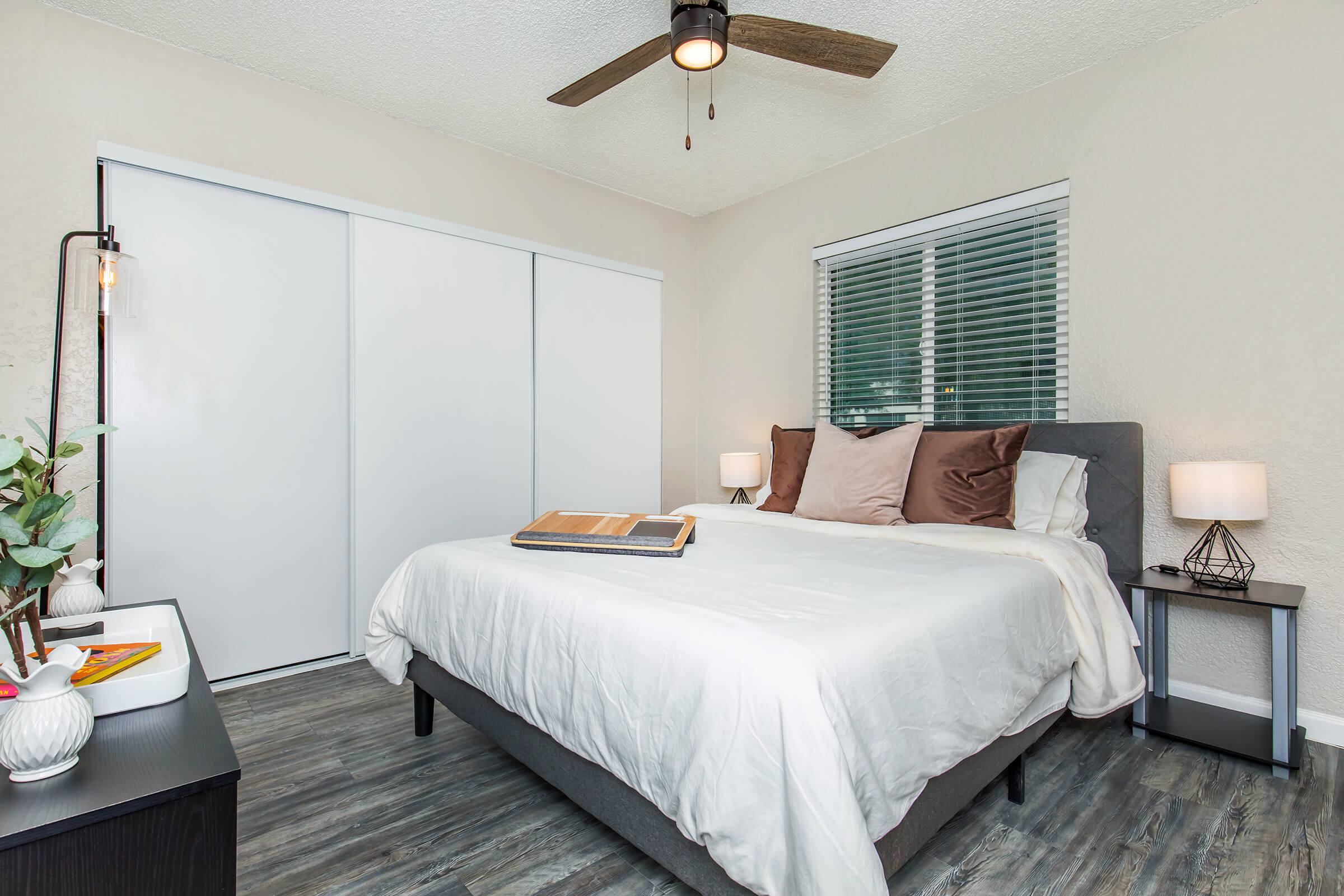 a bedroom with a bed and desk in a hotel room