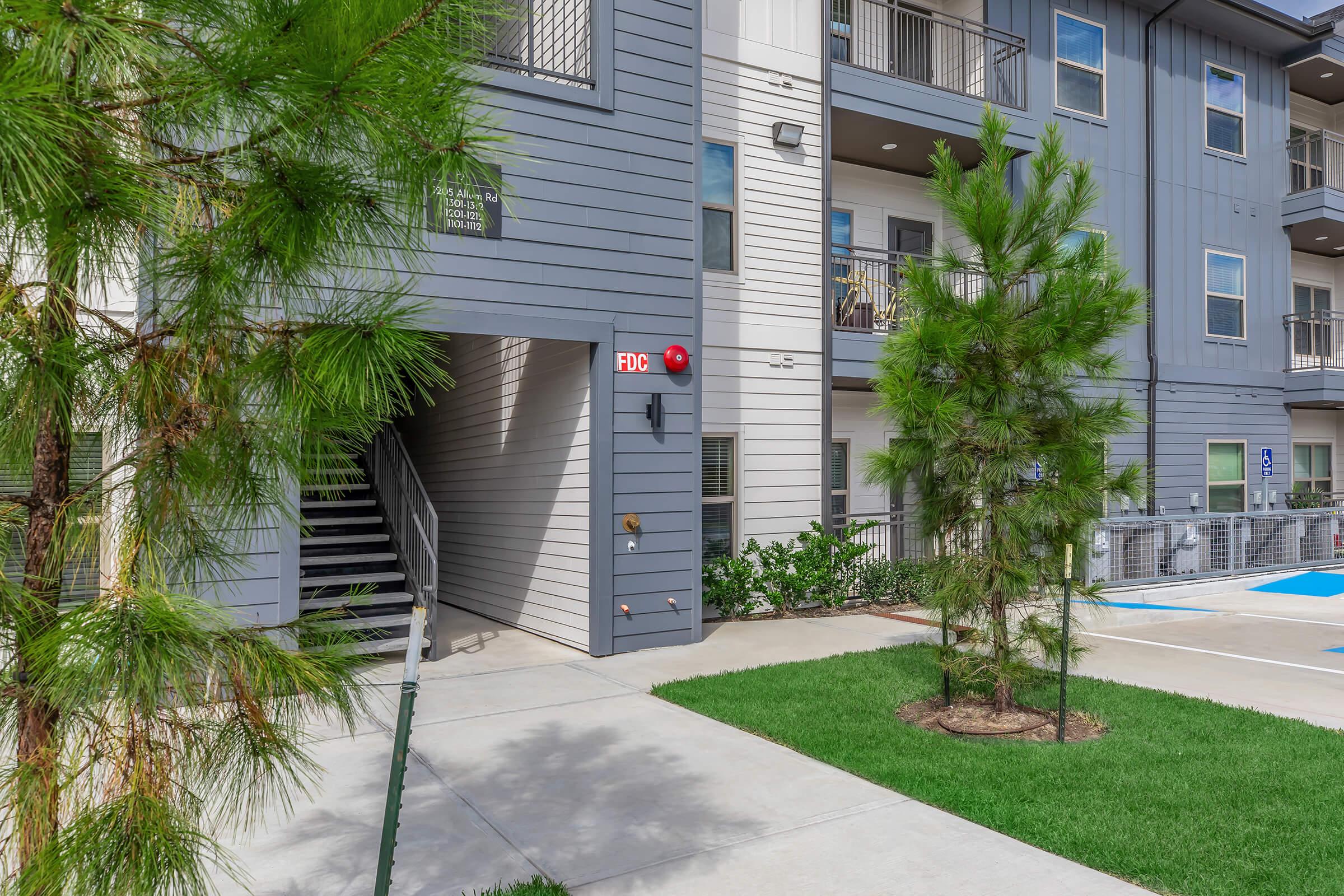 a path with trees on the side of a building