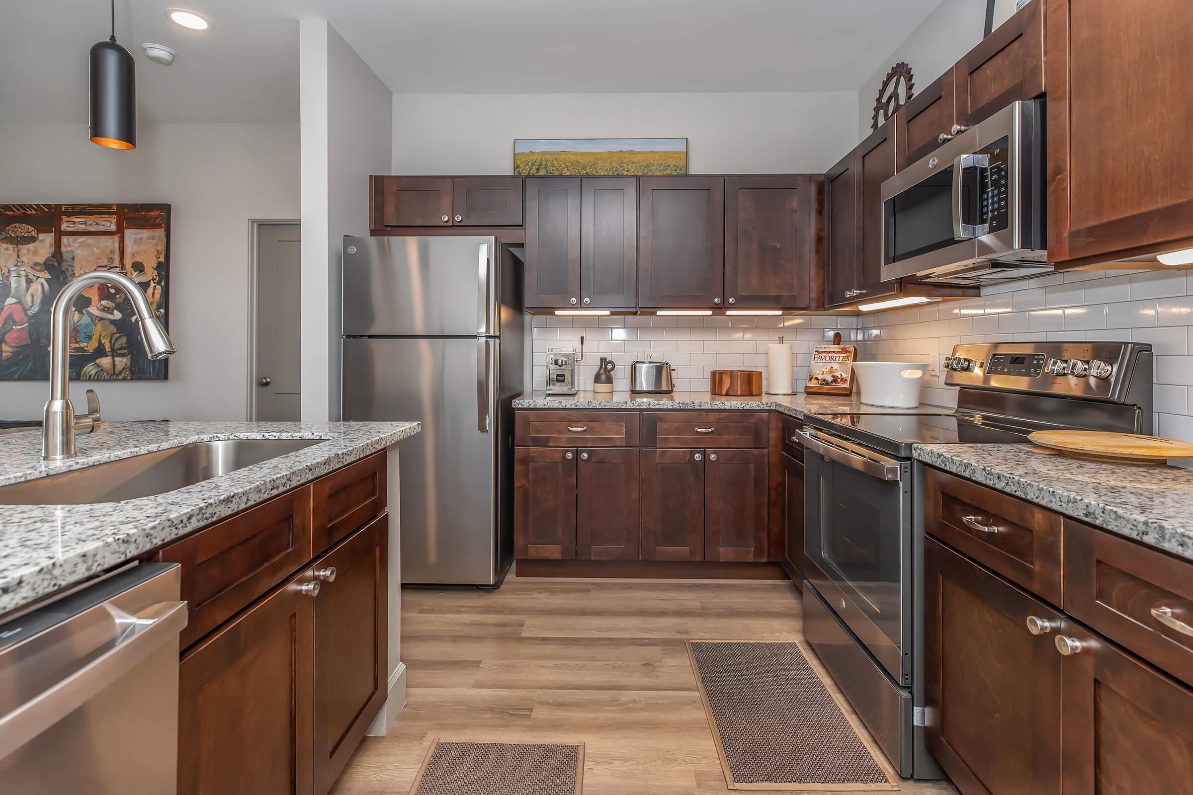 a modern kitchen with stainless steel appliances and wooden cabinets