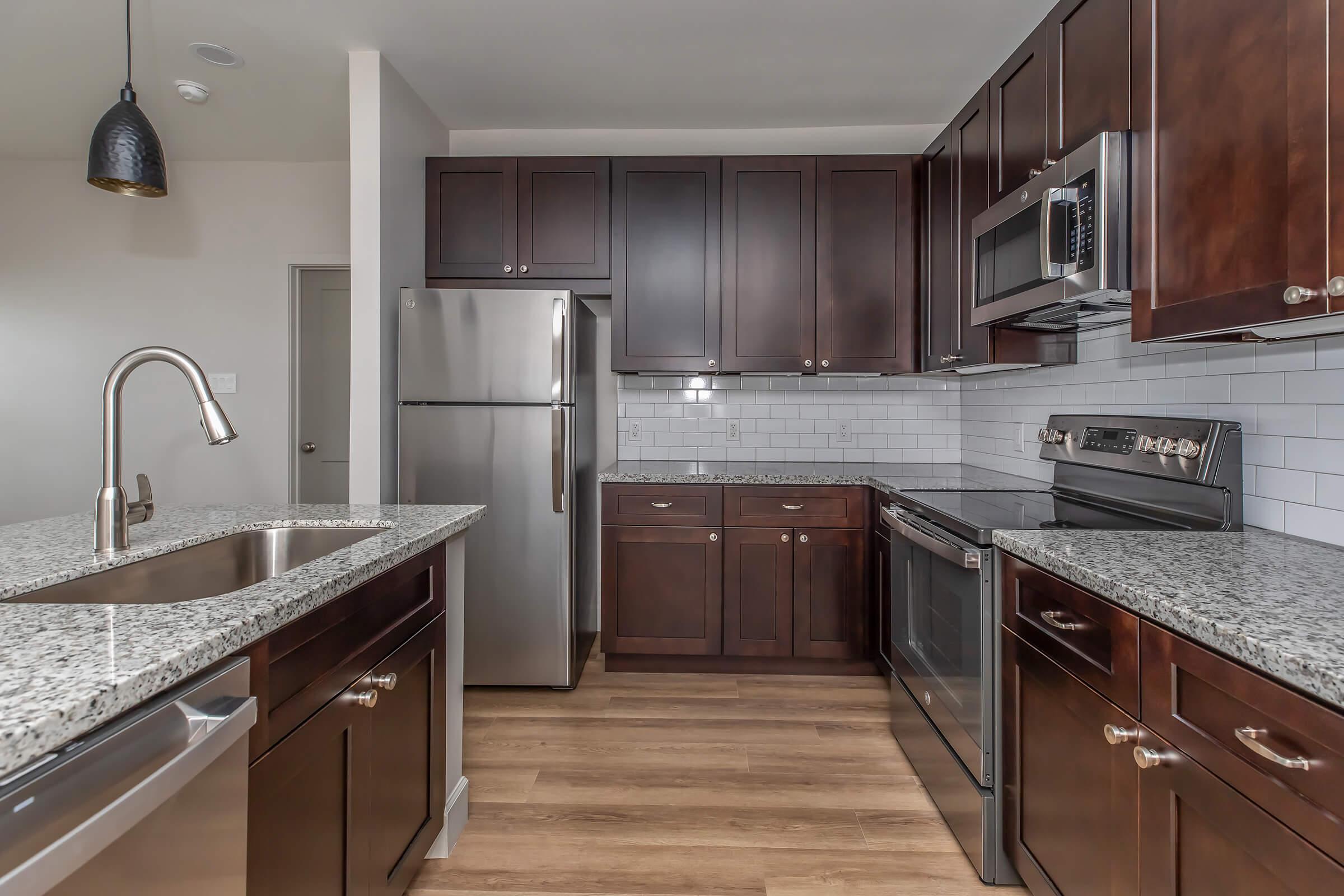 a large kitchen with stainless steel appliances and wooden cabinets