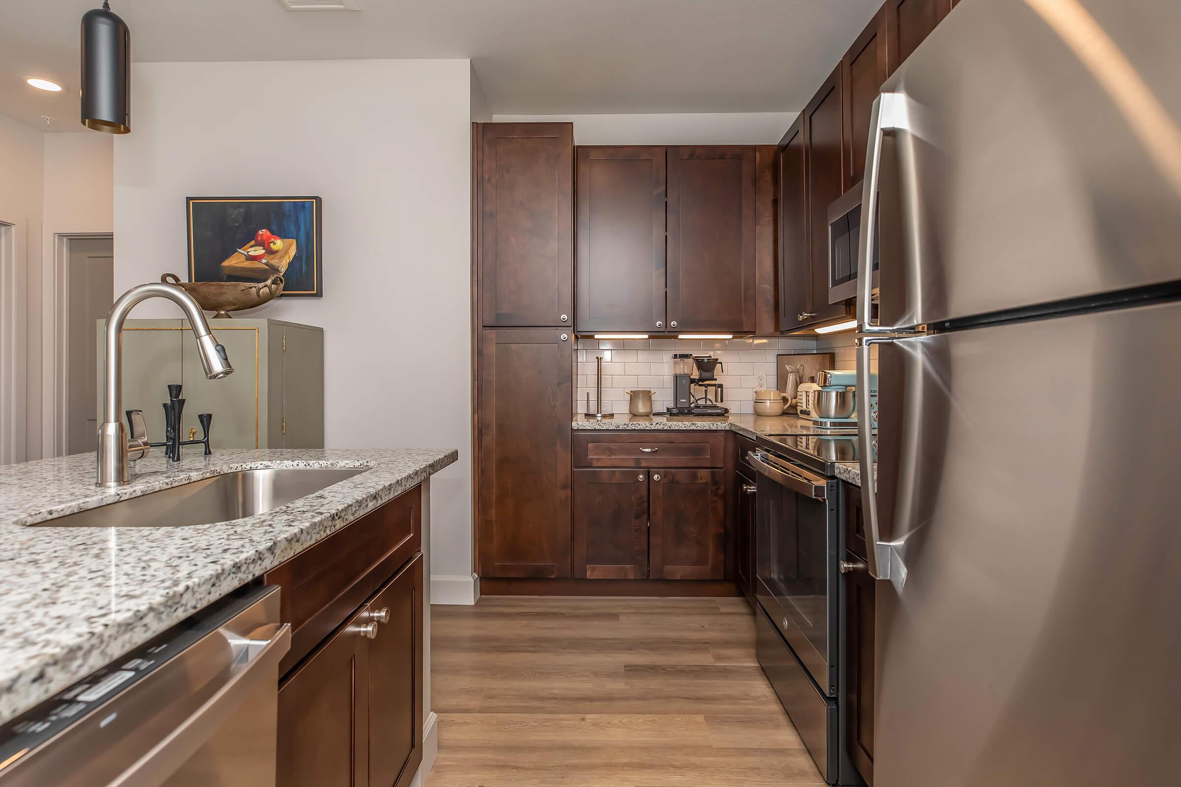 a large kitchen with stainless steel appliances and wooden cabinets