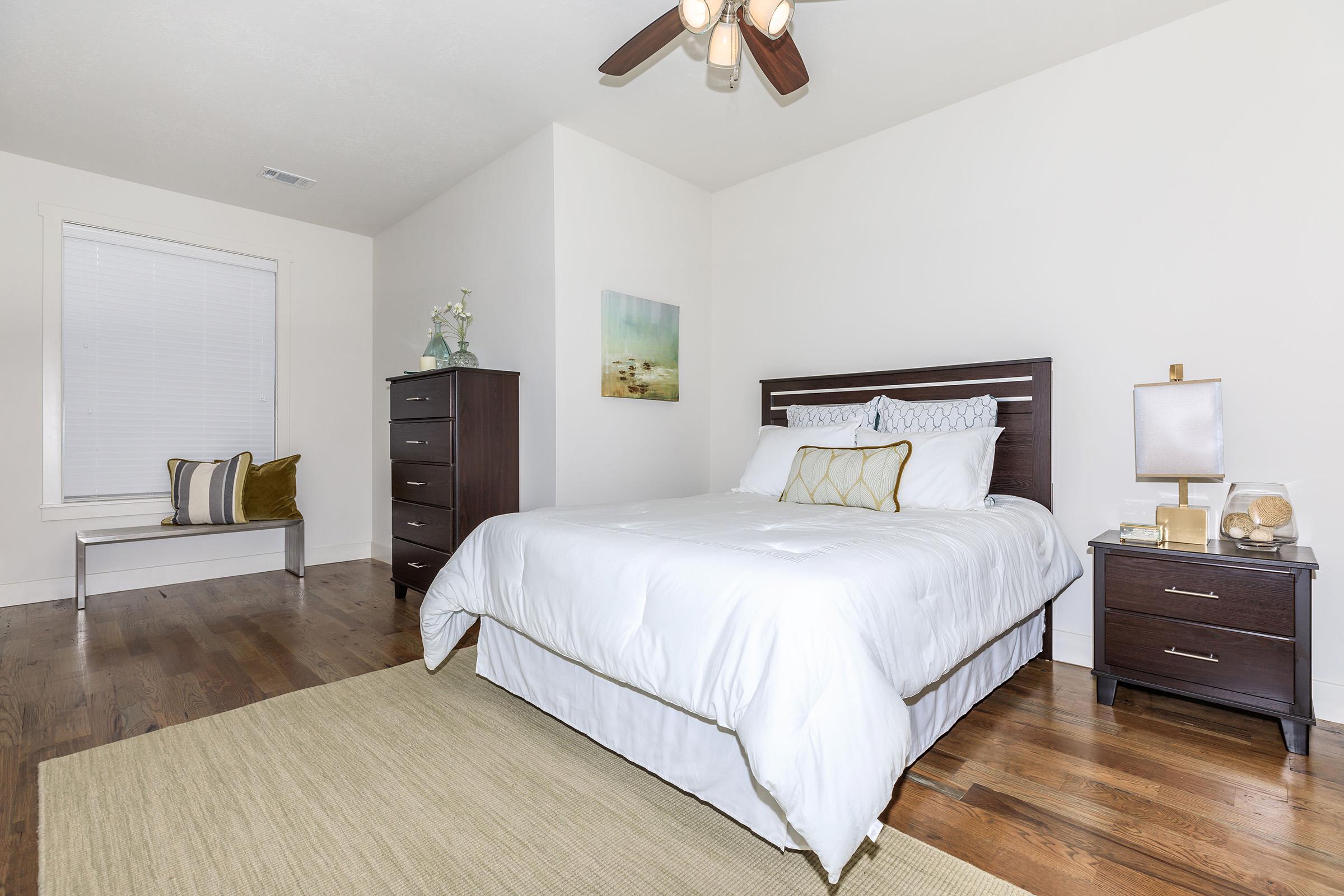 a bedroom with a bed and desk in a room