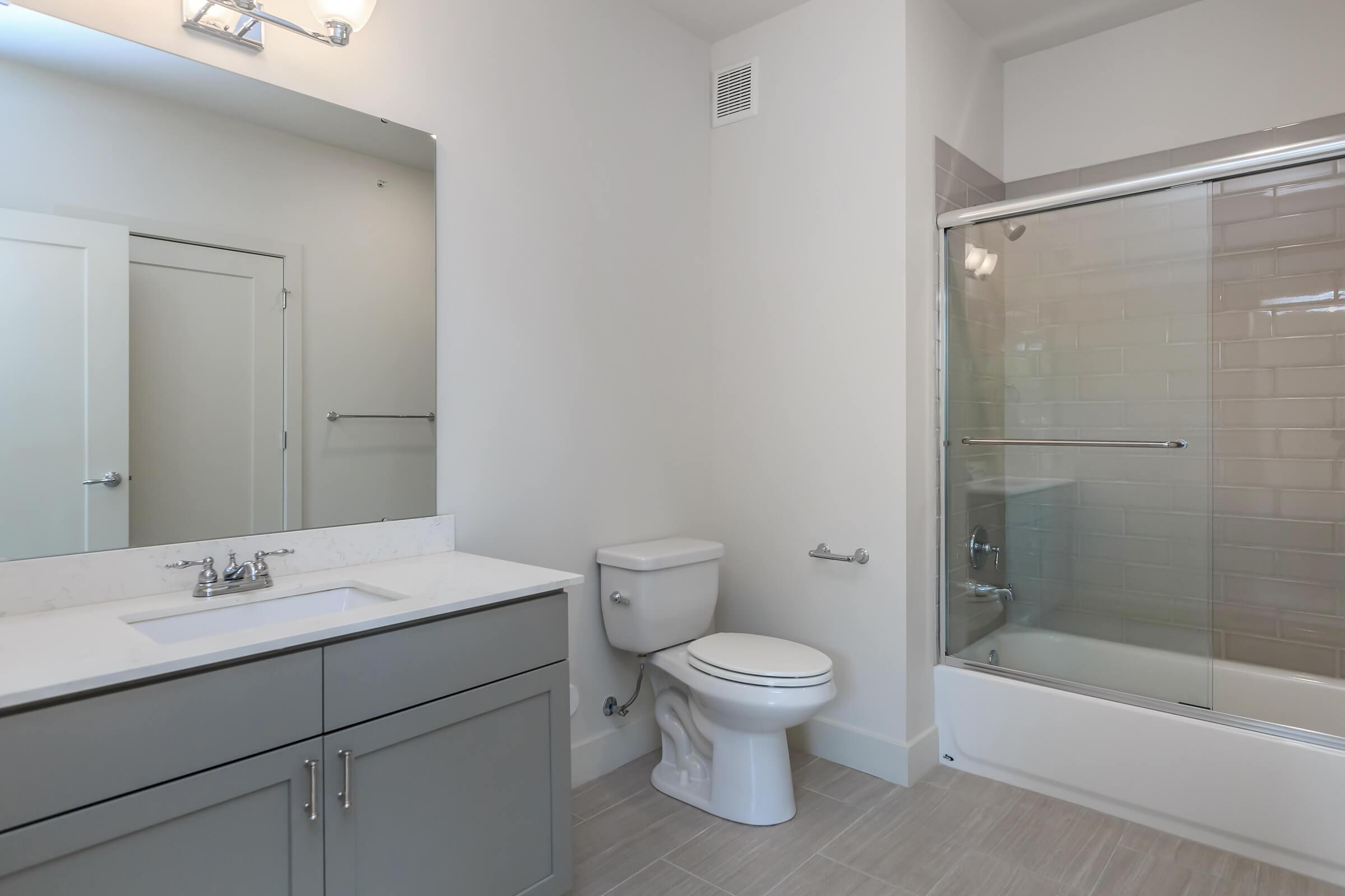 a white sink sitting next to a shower