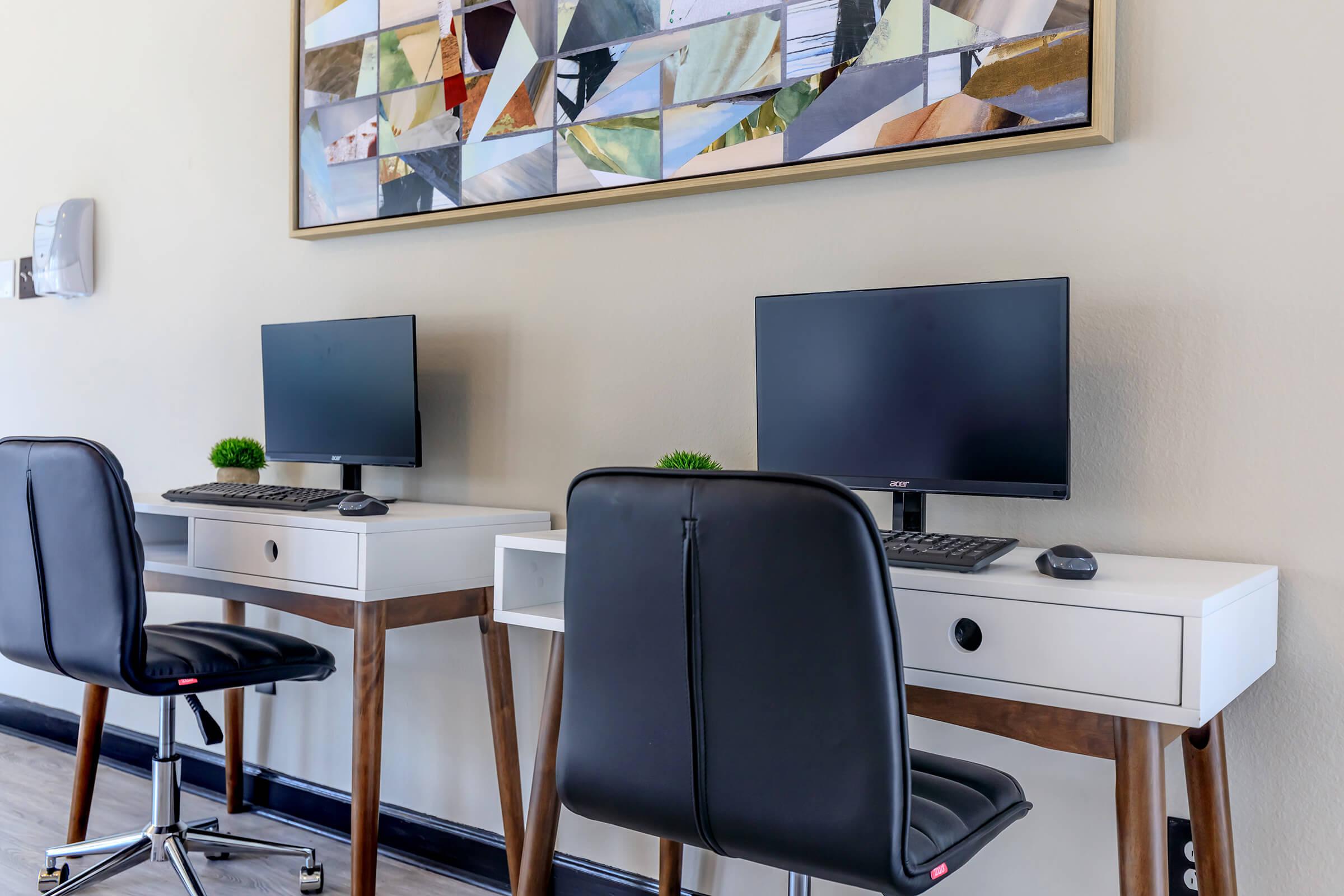 a desk with a computer and a chair in a room