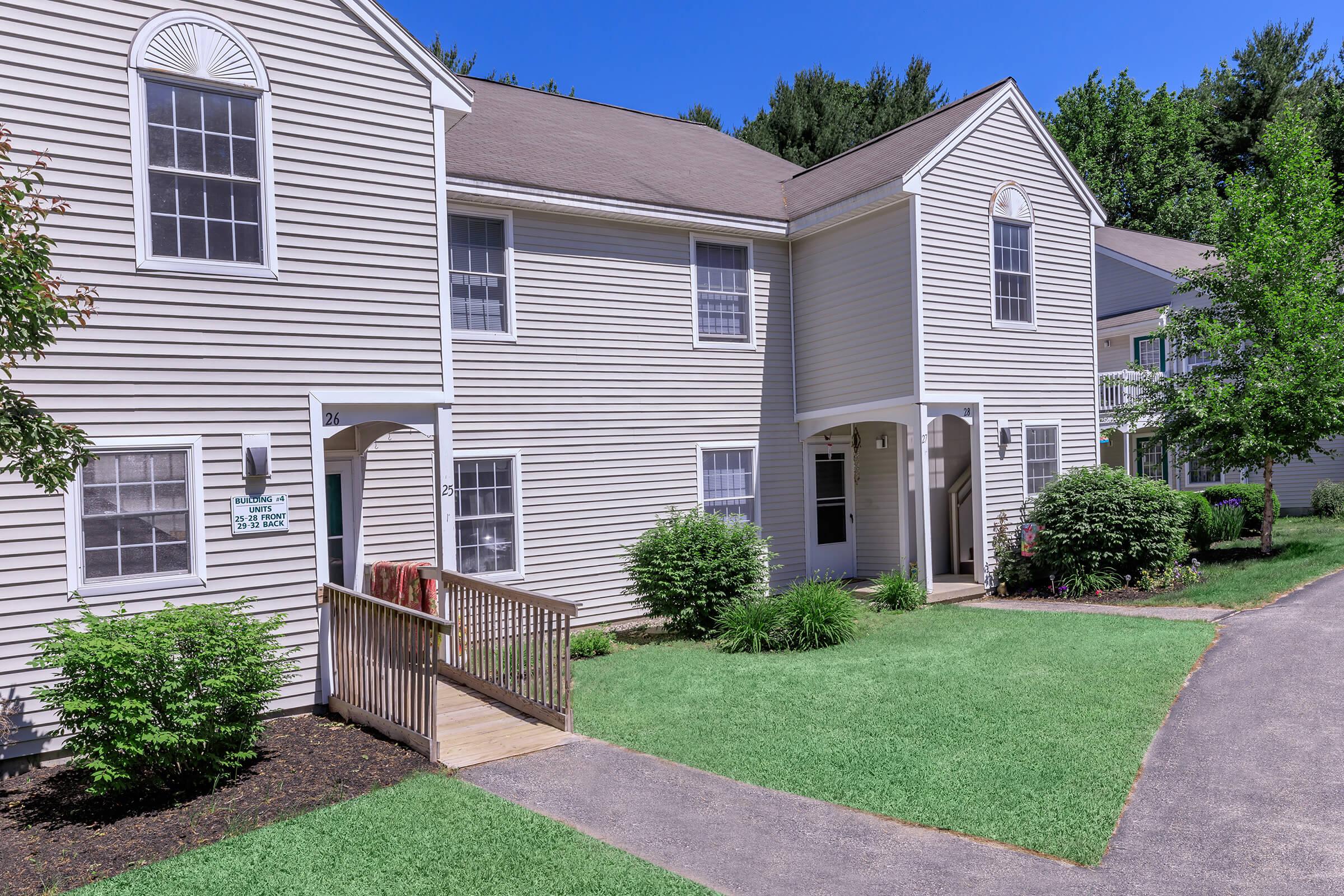 a house with a lawn in front of a brick building