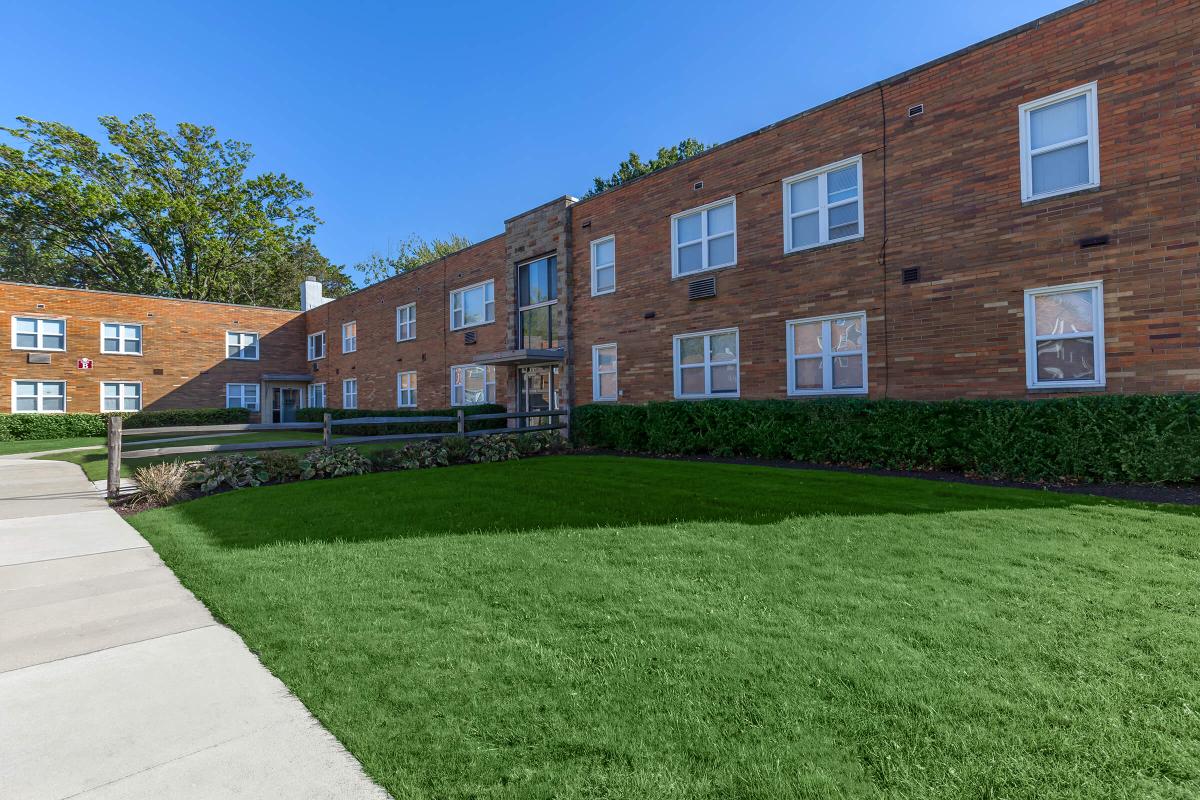 a large lawn in front of a brick building