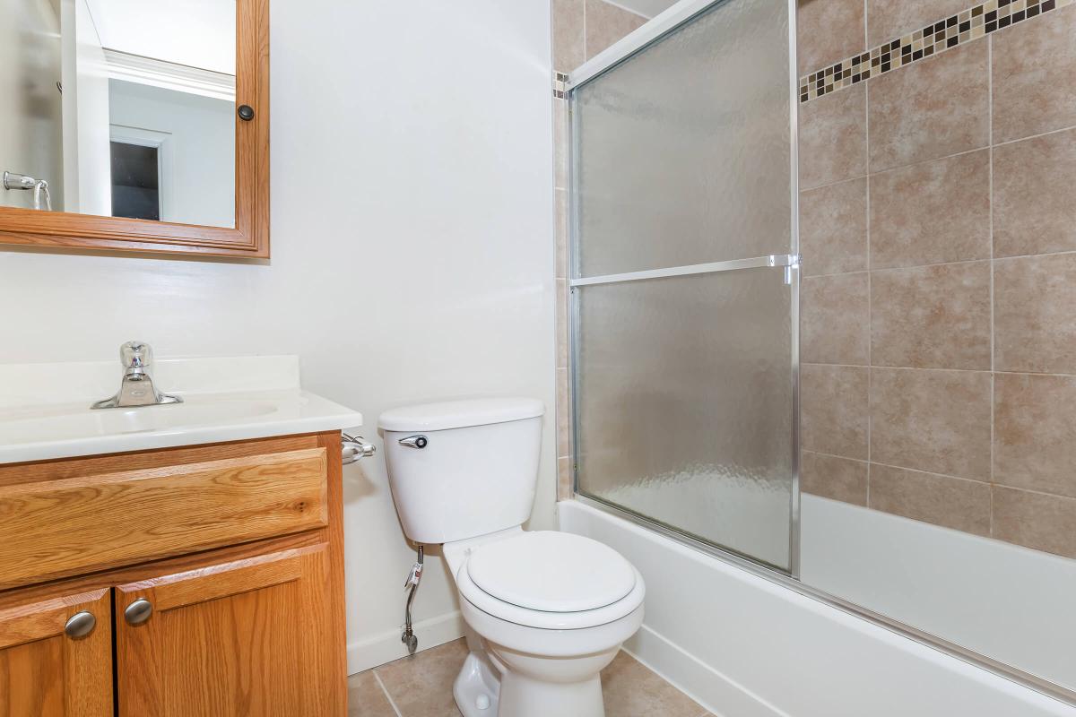 a white sink sitting next to a shower