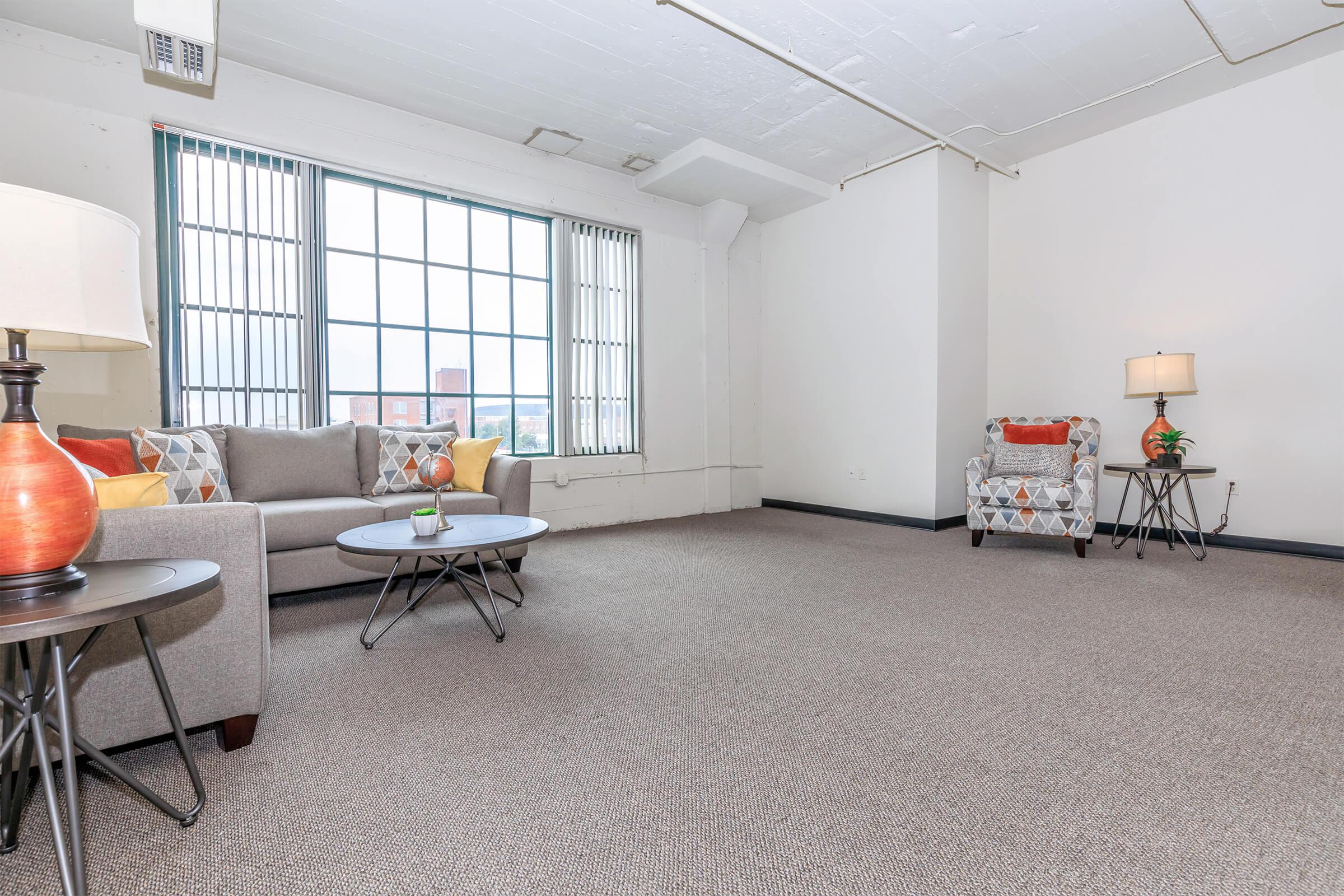 a living room filled with furniture and a large window