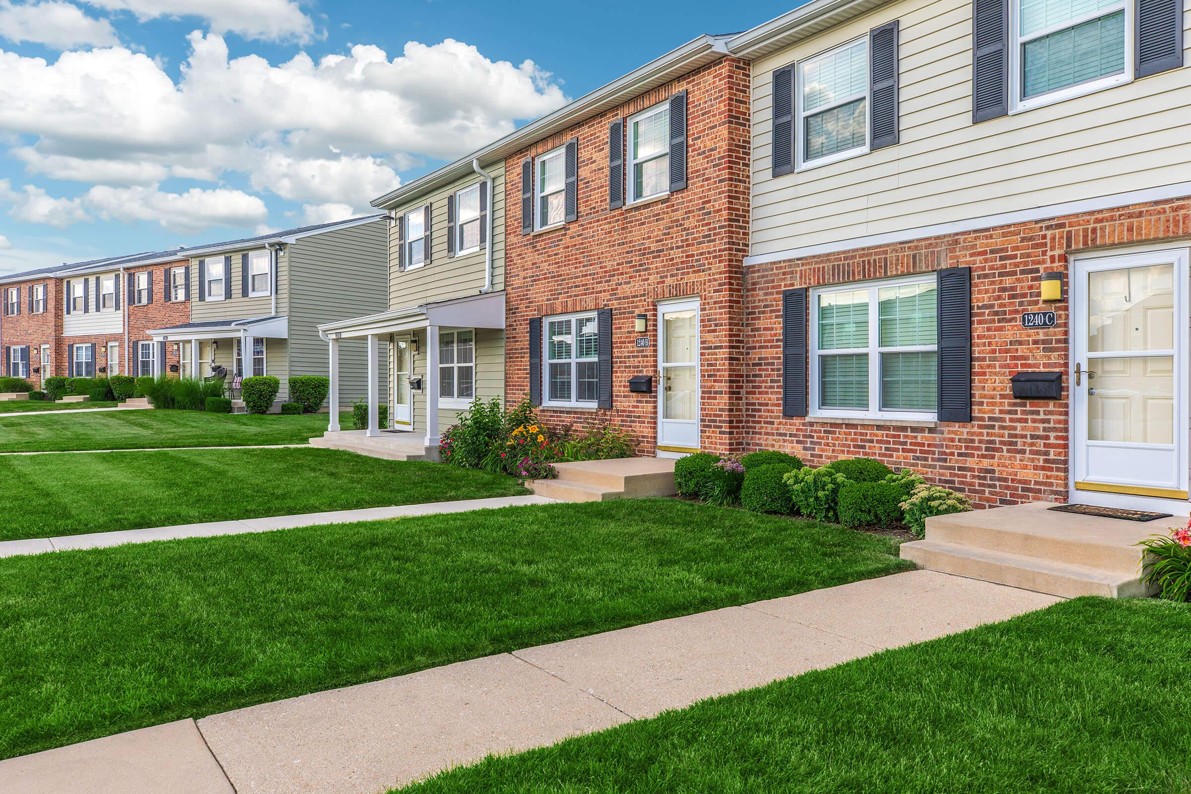 a large lawn in front of a brick building