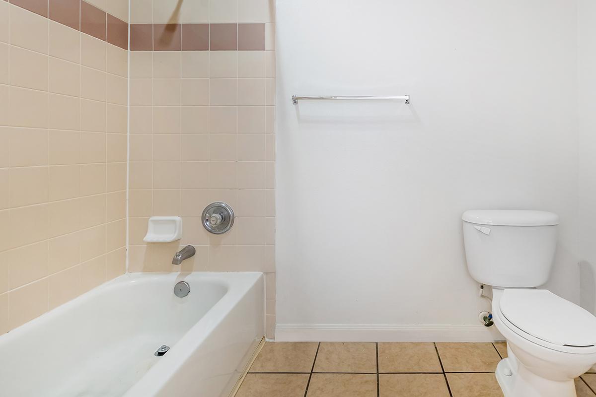 a white sink sitting next to a tiled wall