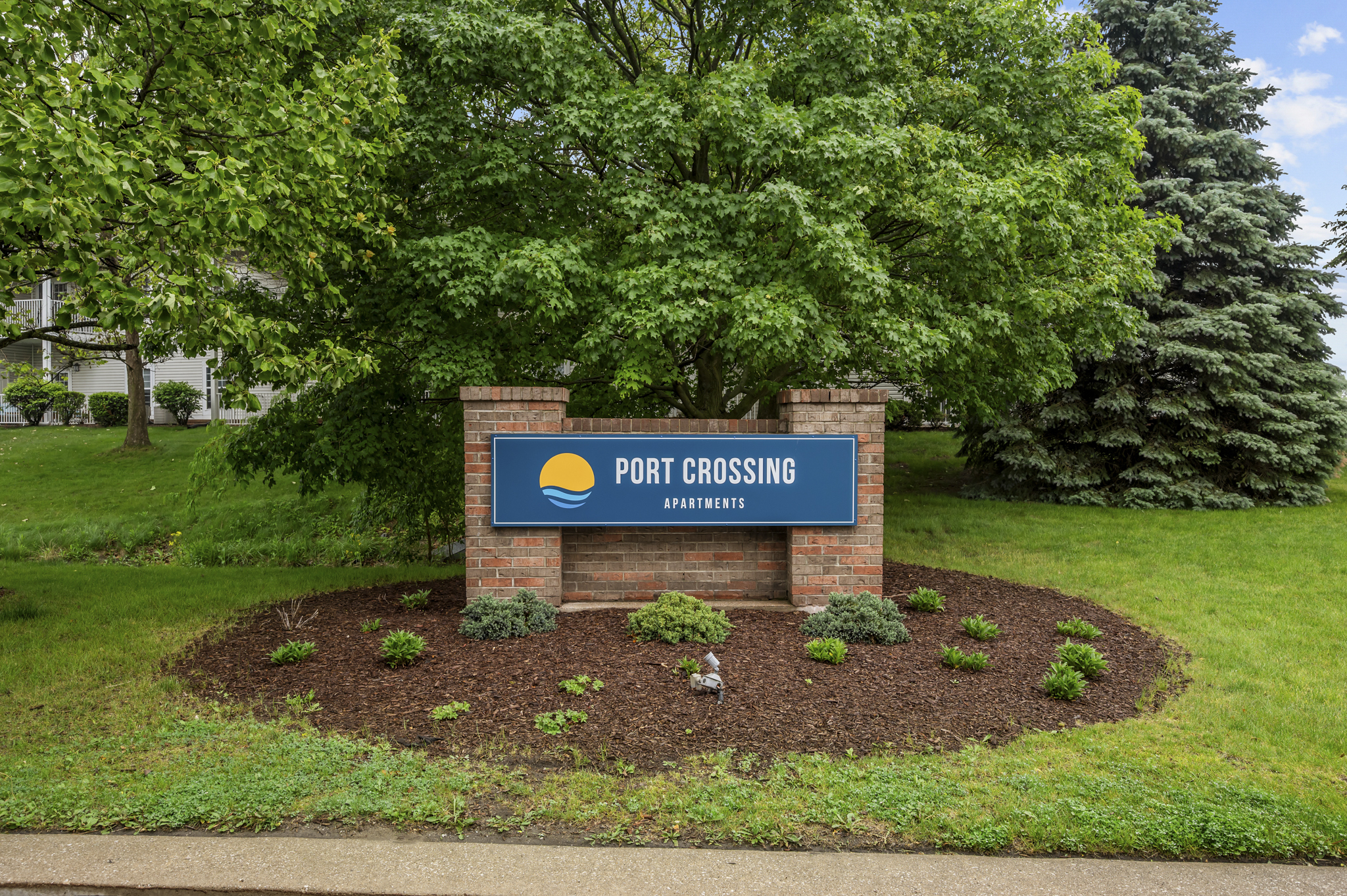 Brick monument sign with blue Port Crossing sign