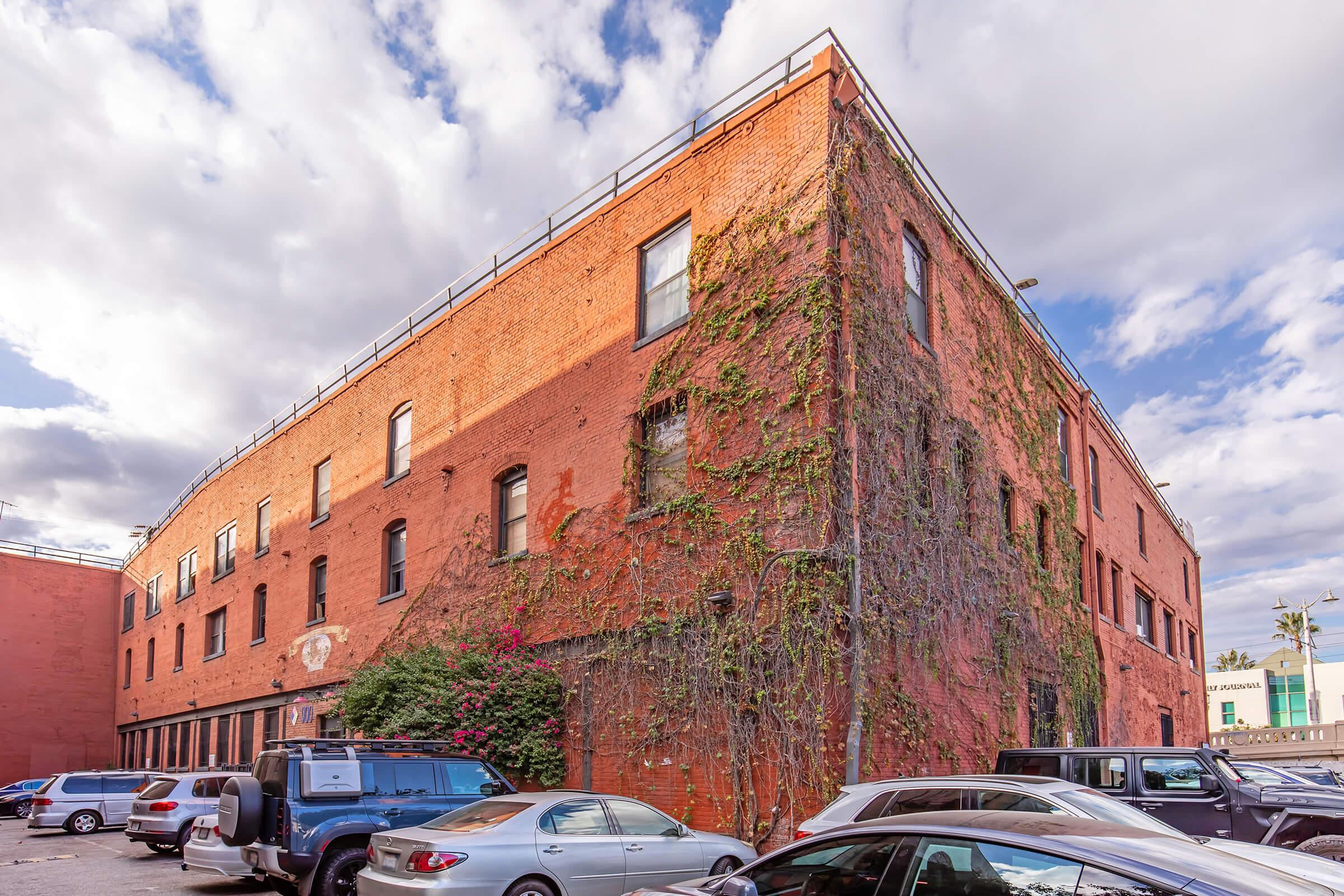 a large brick building with a car parked on the side of a road