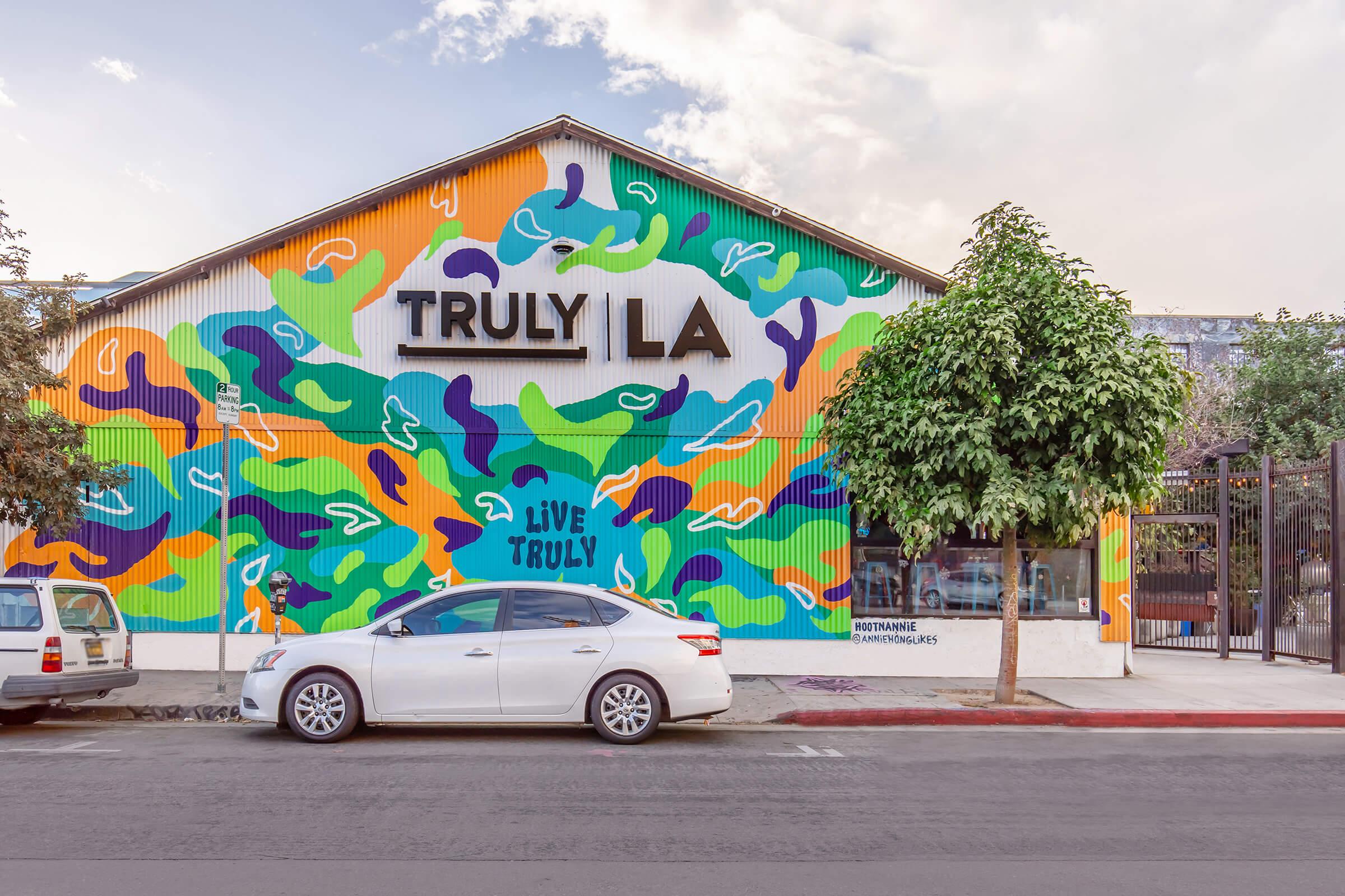 a car parked in front of a graffiti covered wall