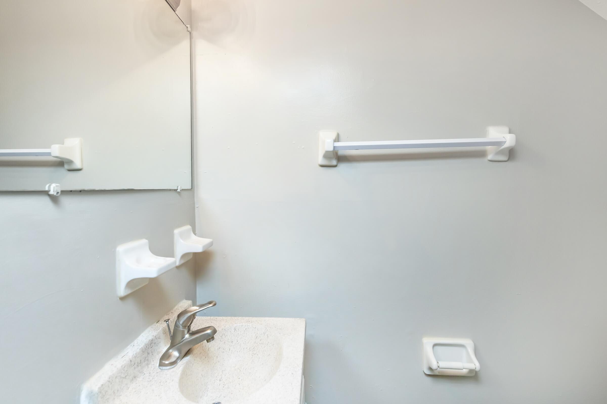 a white sink sitting under a mirror