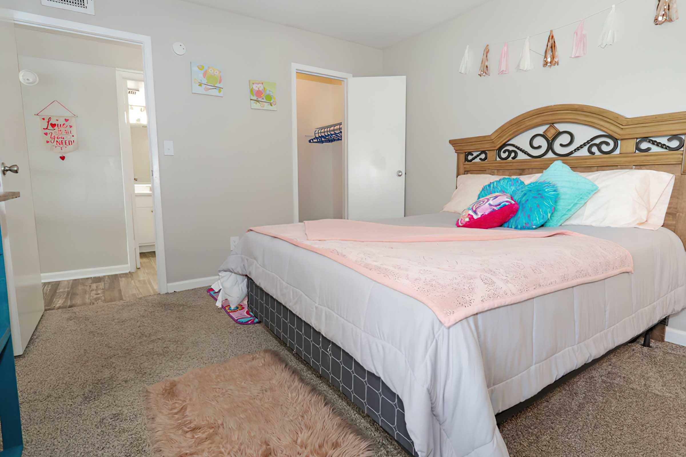 a bedroom with a bed and desk in a room