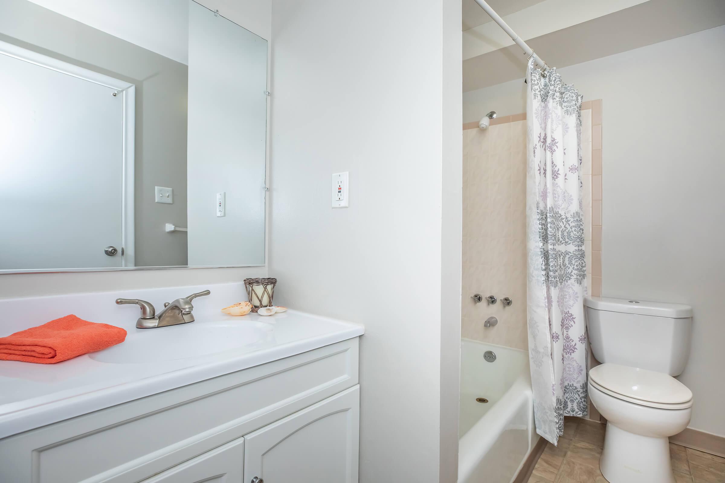 a white sink sitting next to a shower