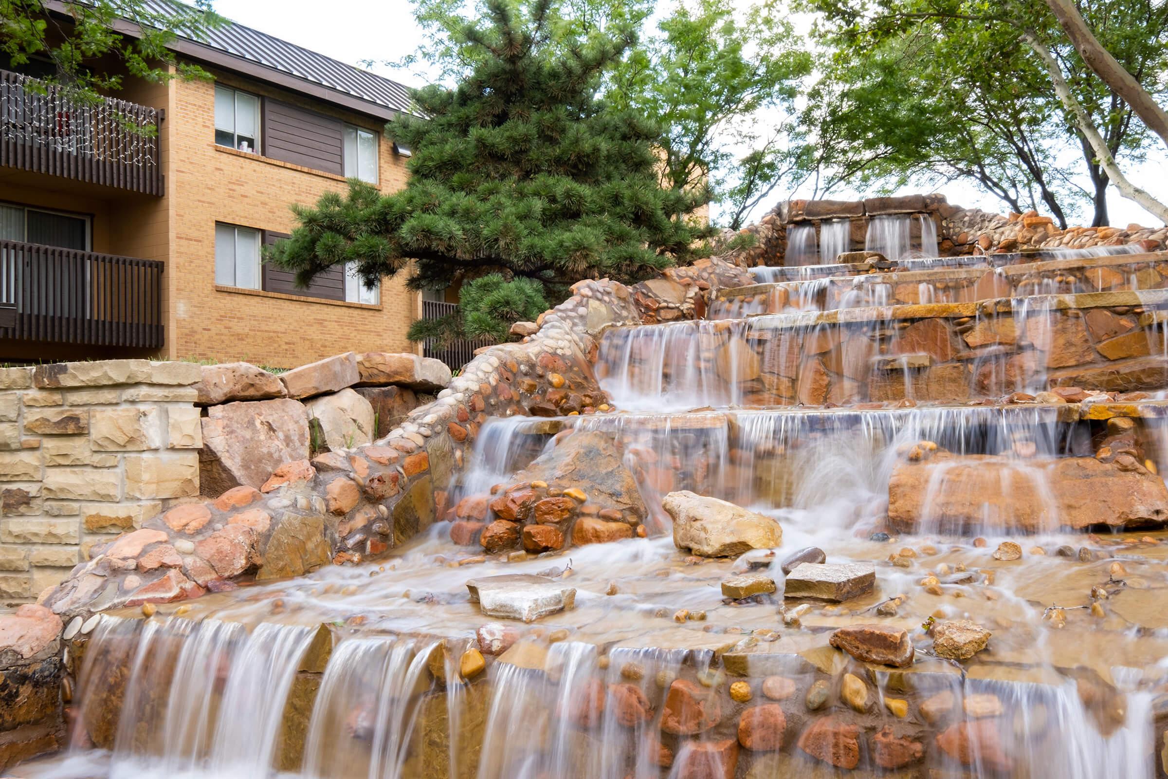 a large waterfall in front of a building