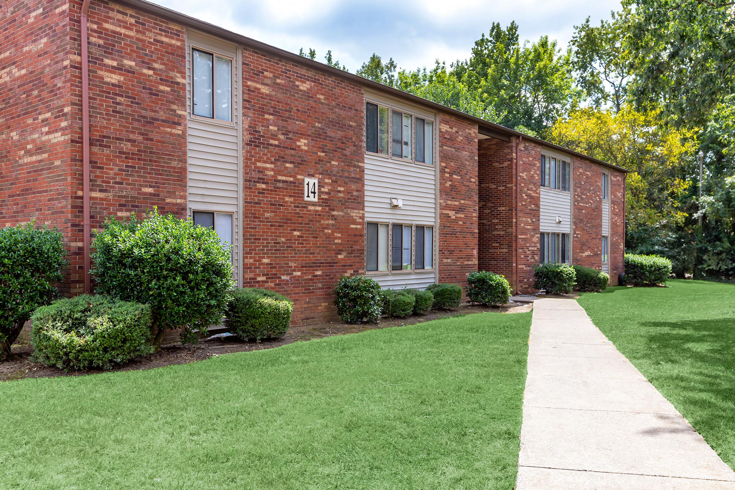 a large lawn in front of a brick building