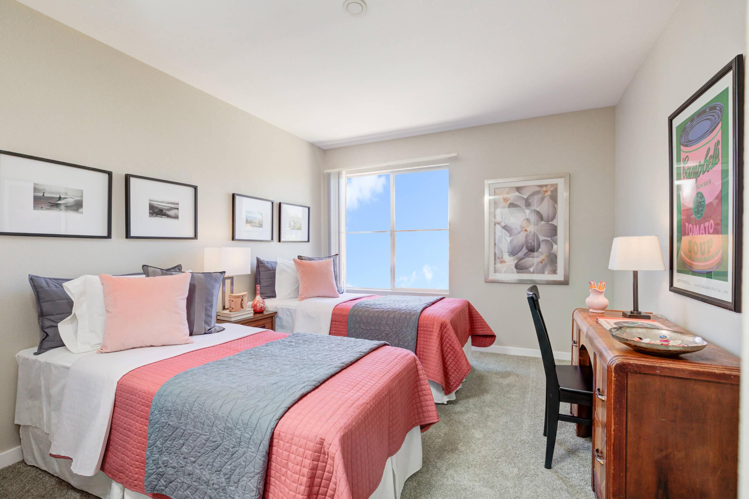 a bedroom with a bed and desk in a hotel room