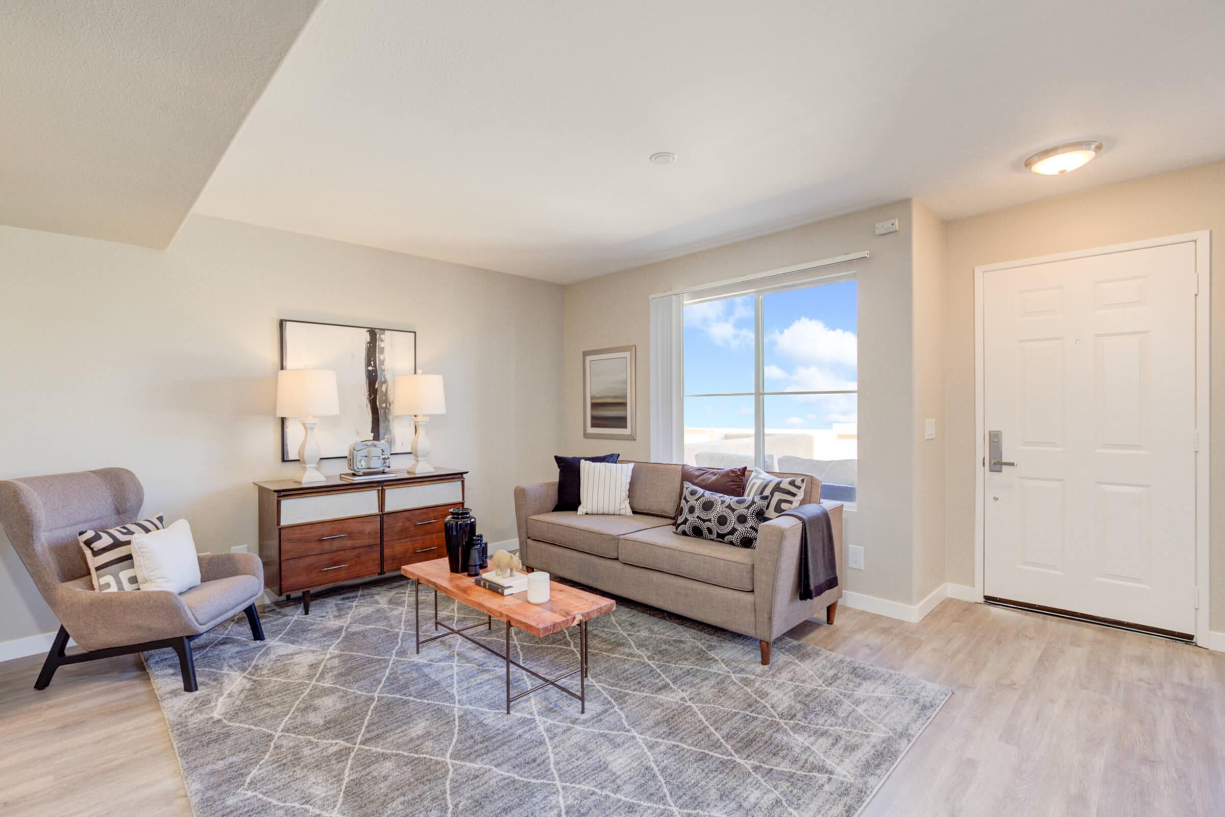 a living room filled with furniture and a large window