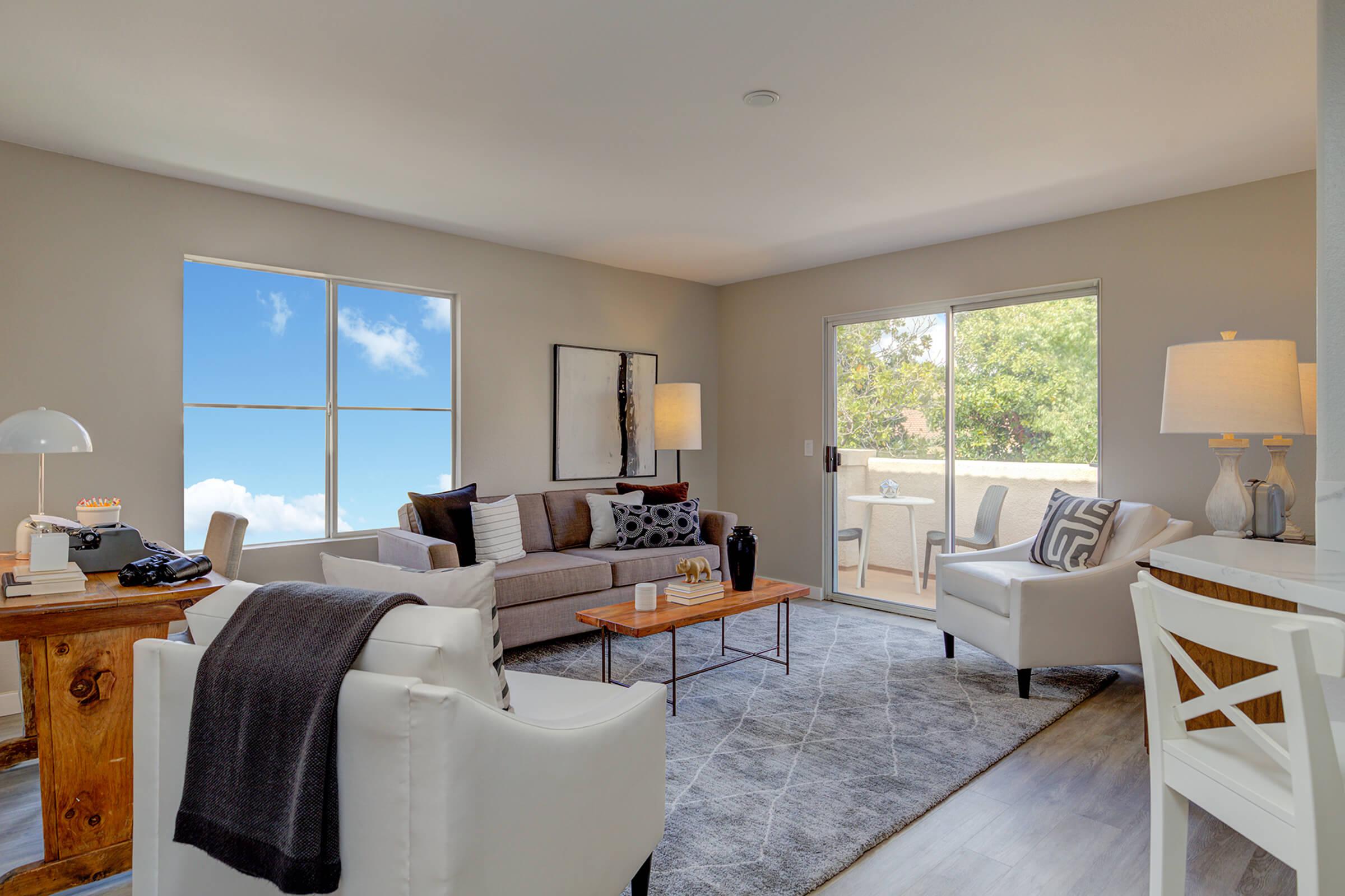 a living room filled with furniture and a large window