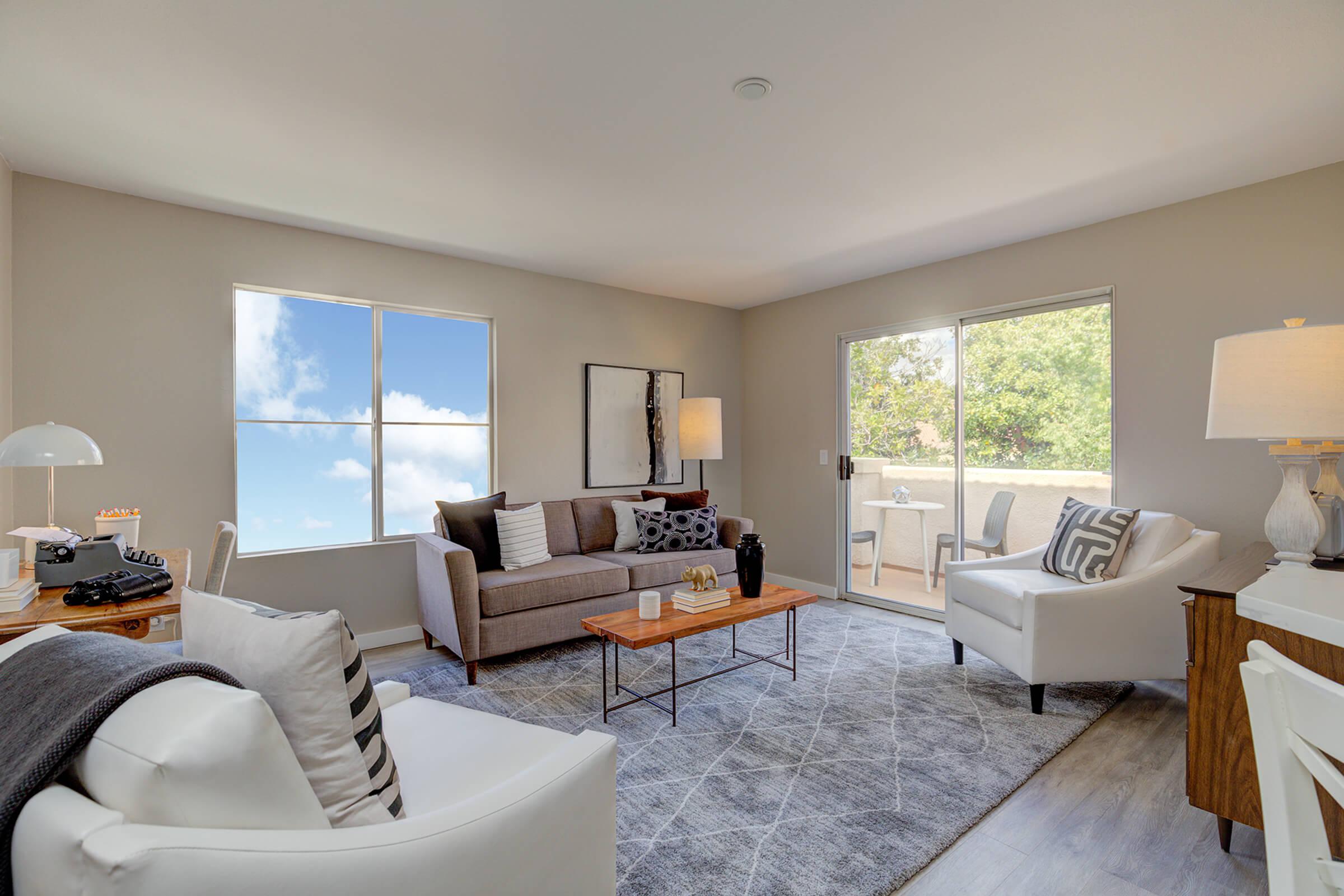 a view of a living room filled with furniture and a large window