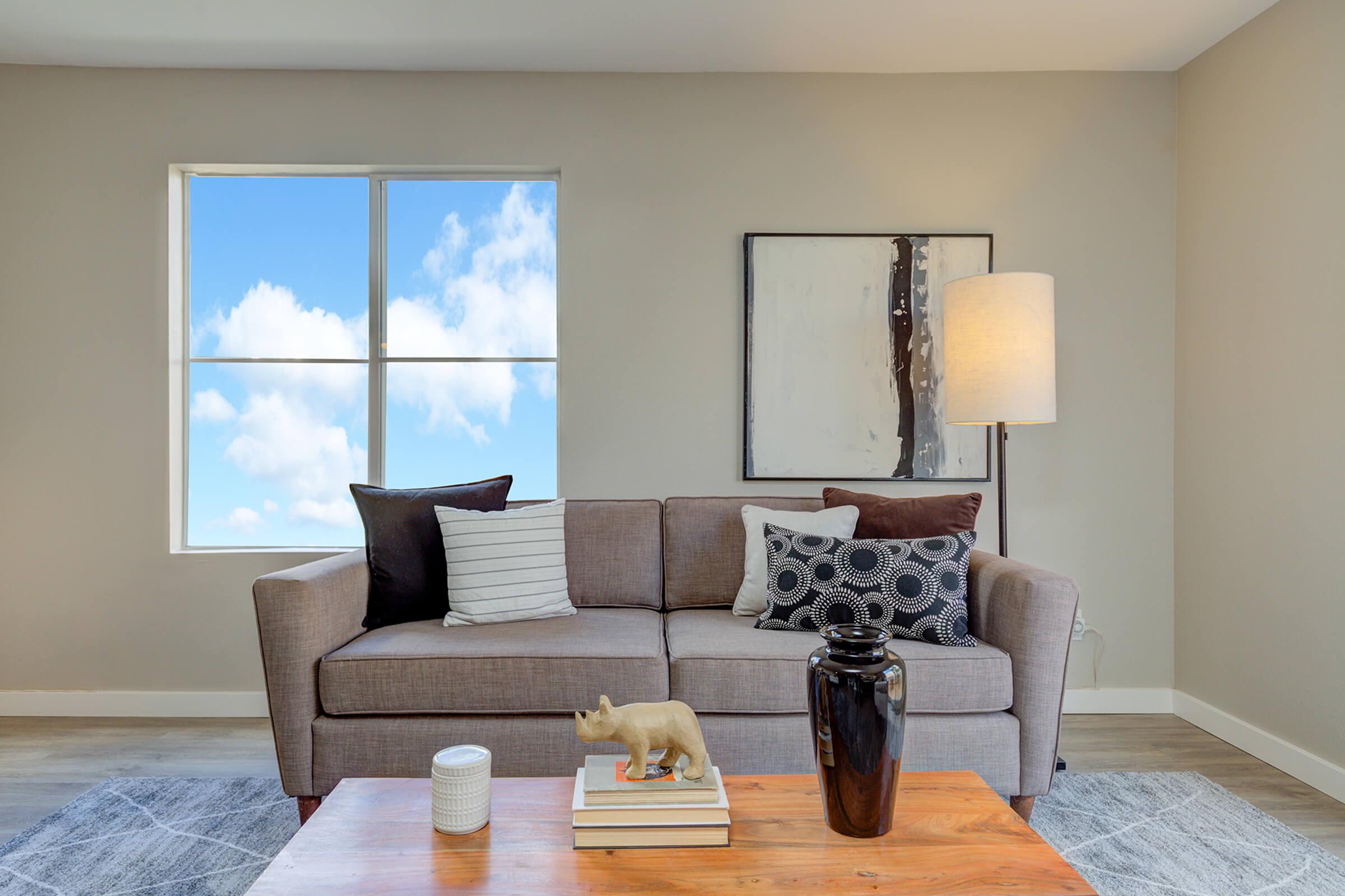 a living room filled with furniture and a large window