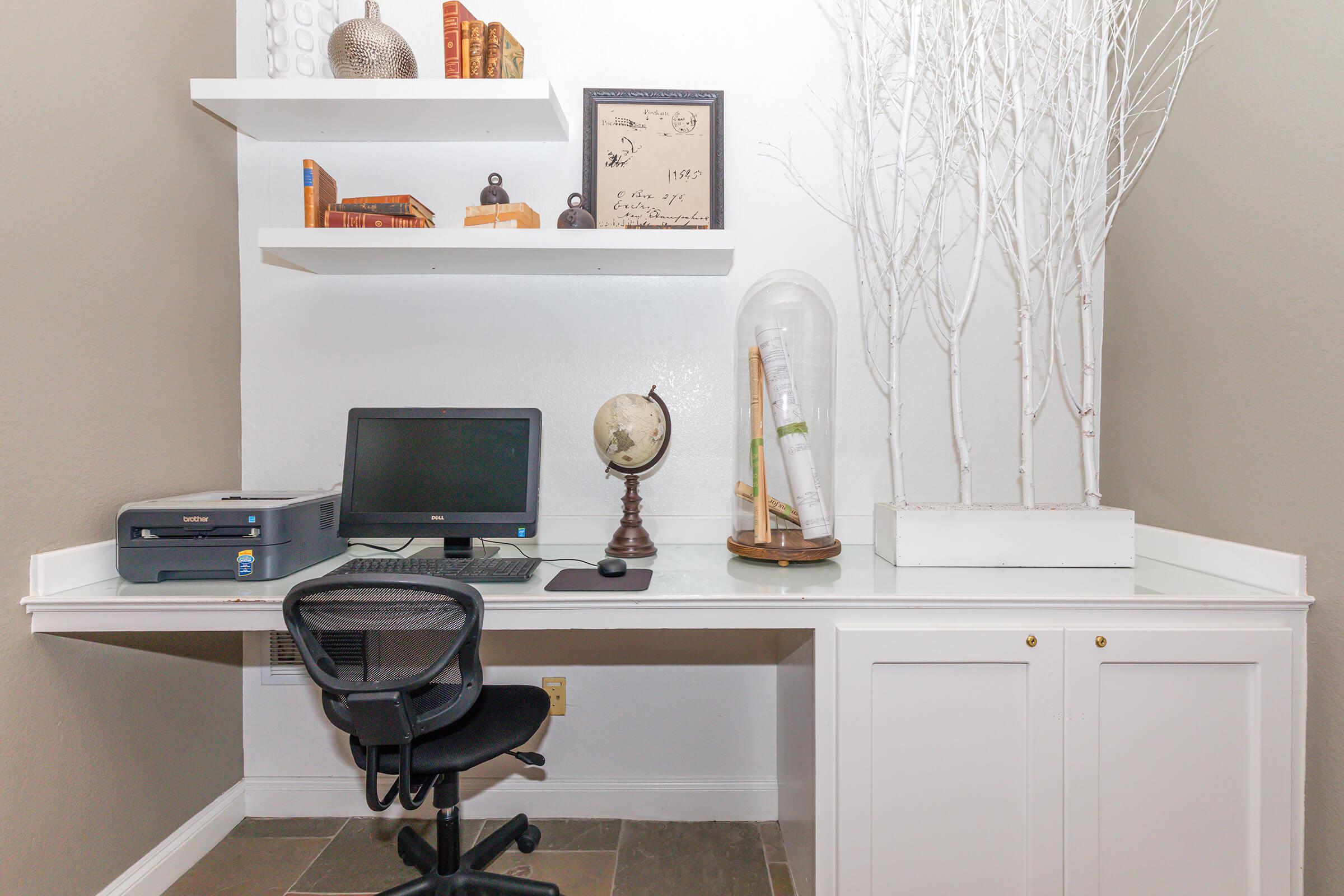 a desk with a computer and chair